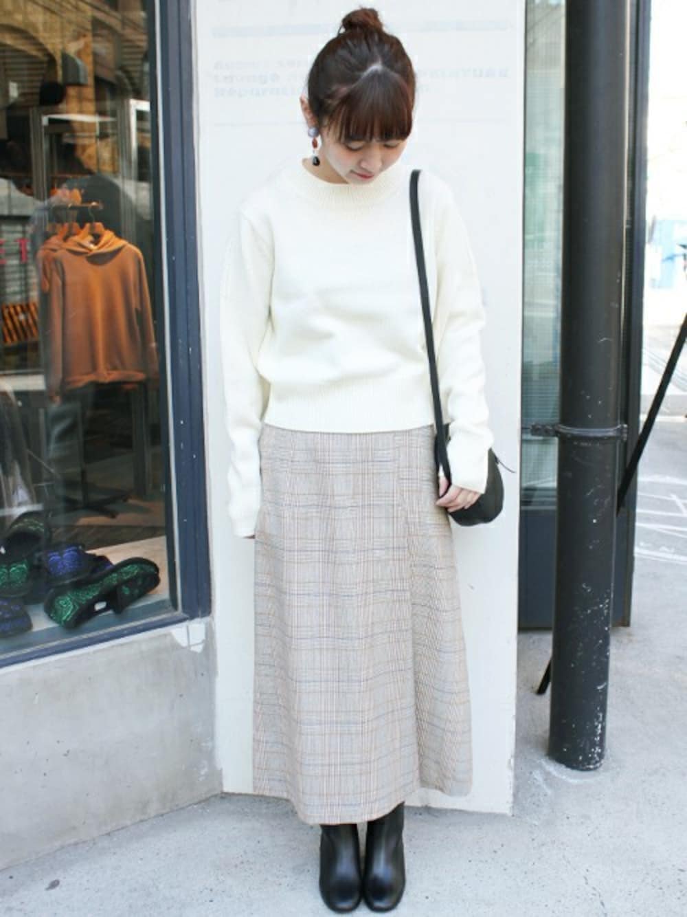ホワイト系のニット/セーター、グレー系のスカート、ブラック系のブーツを着用したレディースの冬コーディネートの1枚目の写真
