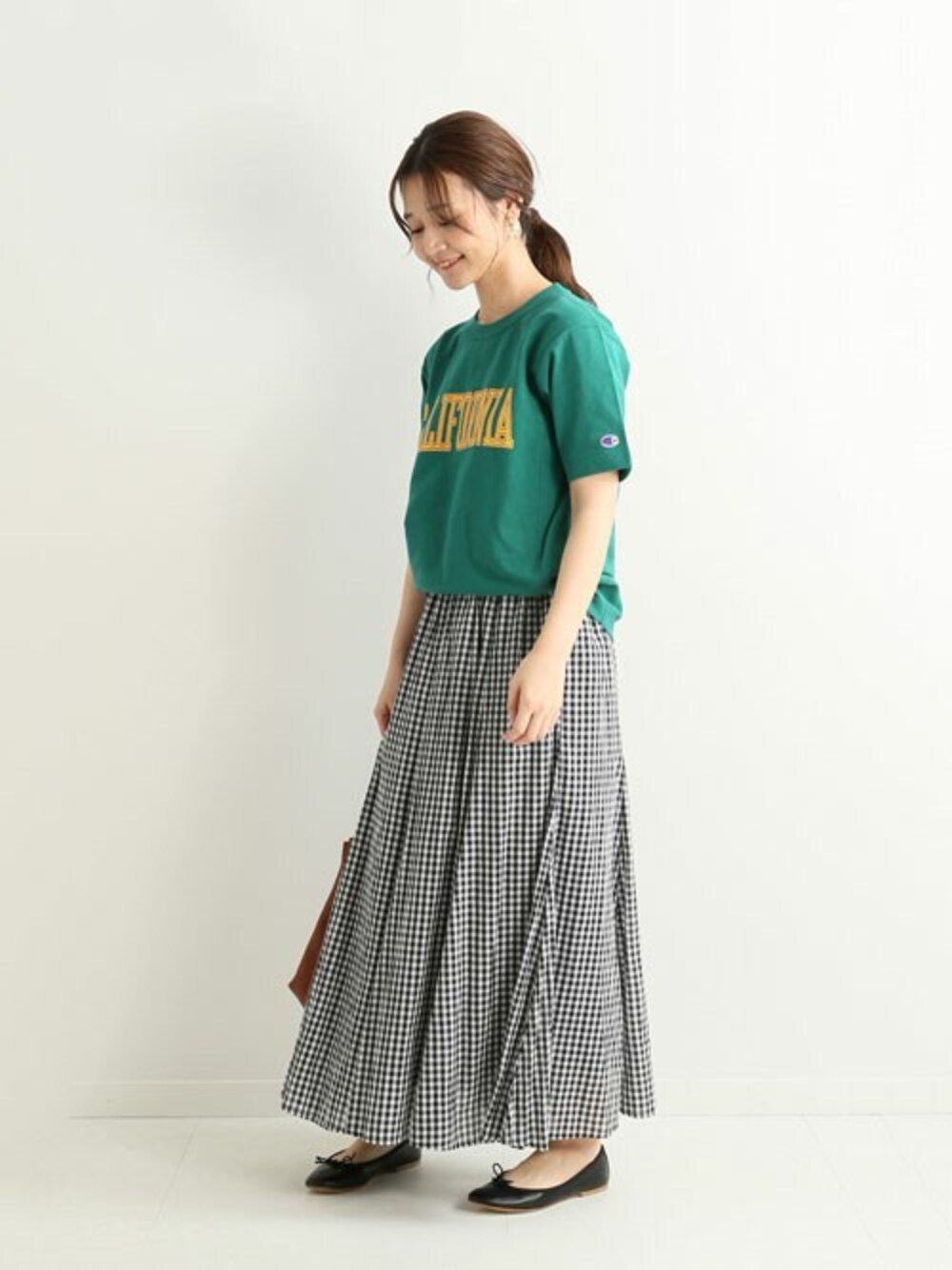 グリーン系のTシャツ/カットソー、ブラック系のスカート、ブラック系のバレエシューズを着用したレディースの春コーディネートの1枚目の写真