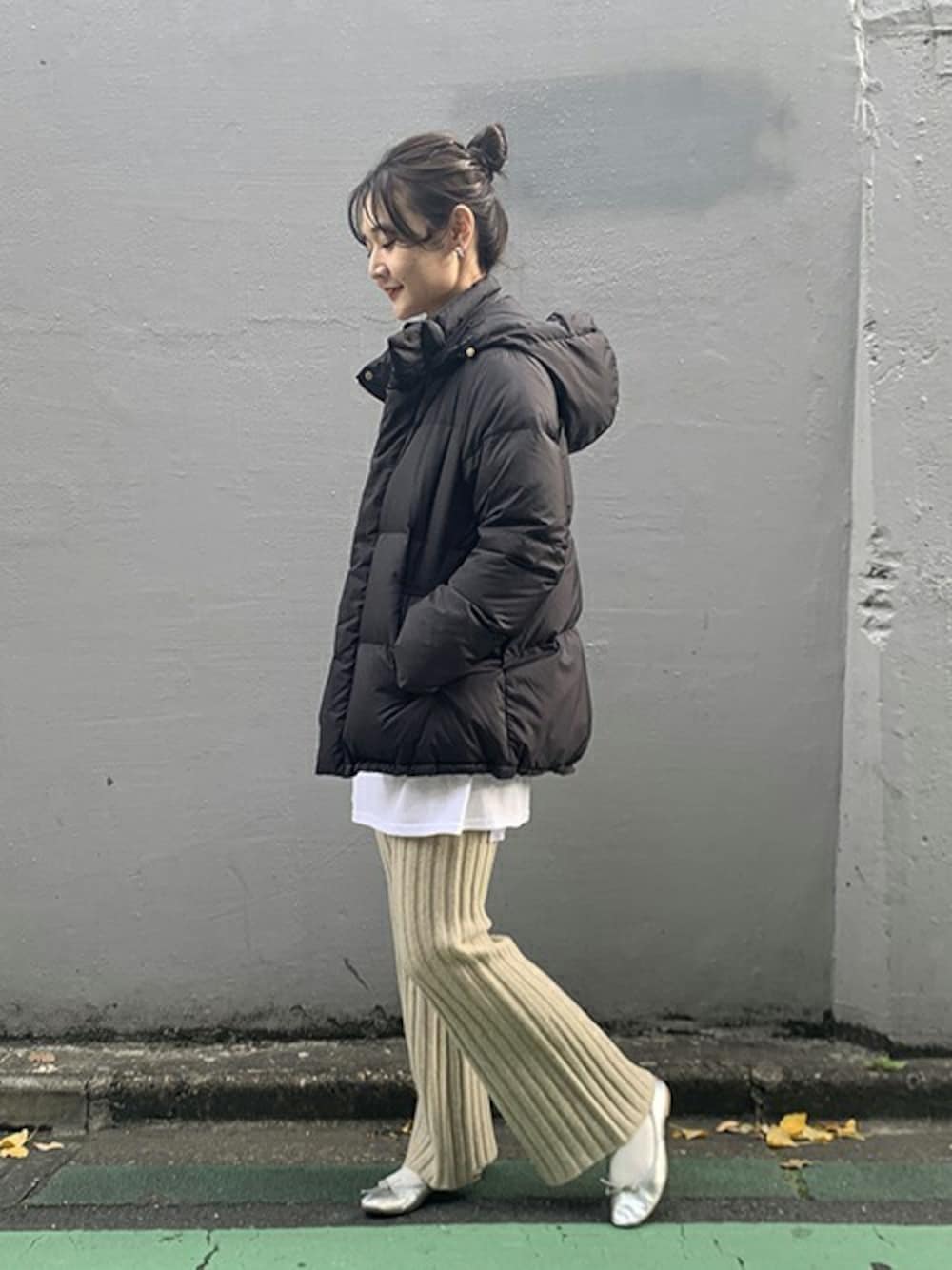 ブラック系のダウンジャケット/コート、ホワイト系のTシャツ/カットソー、シルバー系のバレエシューズを着用したレディースの冬コーディネートの1枚目の写真