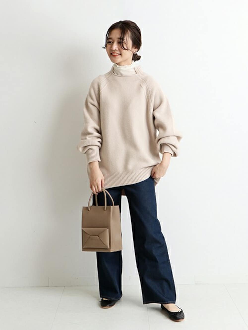 ベージュ系のニット/セーター、ベージュ系のTシャツ/カットソー、ブルー系のデニムパンツを着用したレディースの冬コーディネートの1枚目の写真