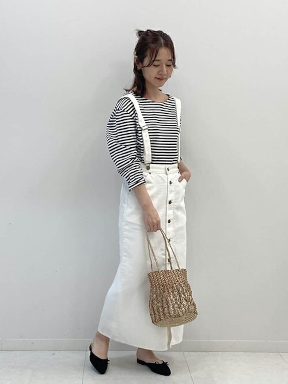 ブラック系のTシャツ/カットソー、ホワイト系のスカート、ゴールド系のハンドバッグを着用したレディースの冬コーディネートの1枚目の写真