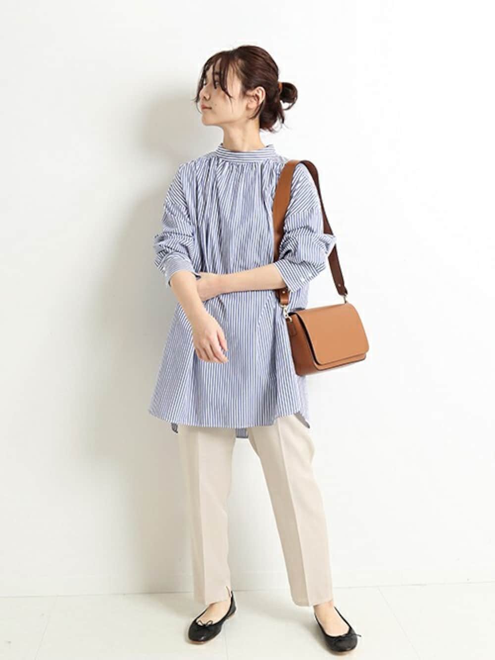 ベージュ系のその他パンツ、ブルー系のシャツ/ブラウス、イエロー系のショルダーバッグを着用したレディースの冬コーディネートの1枚目の写真