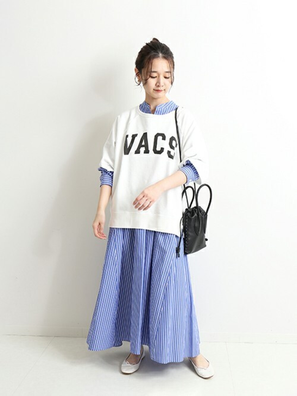 ホワイト系のスウェット、ブルー系のワンピース、ブラック系のショルダーバッグを着用したレディースの春コーディネートの1枚目の写真