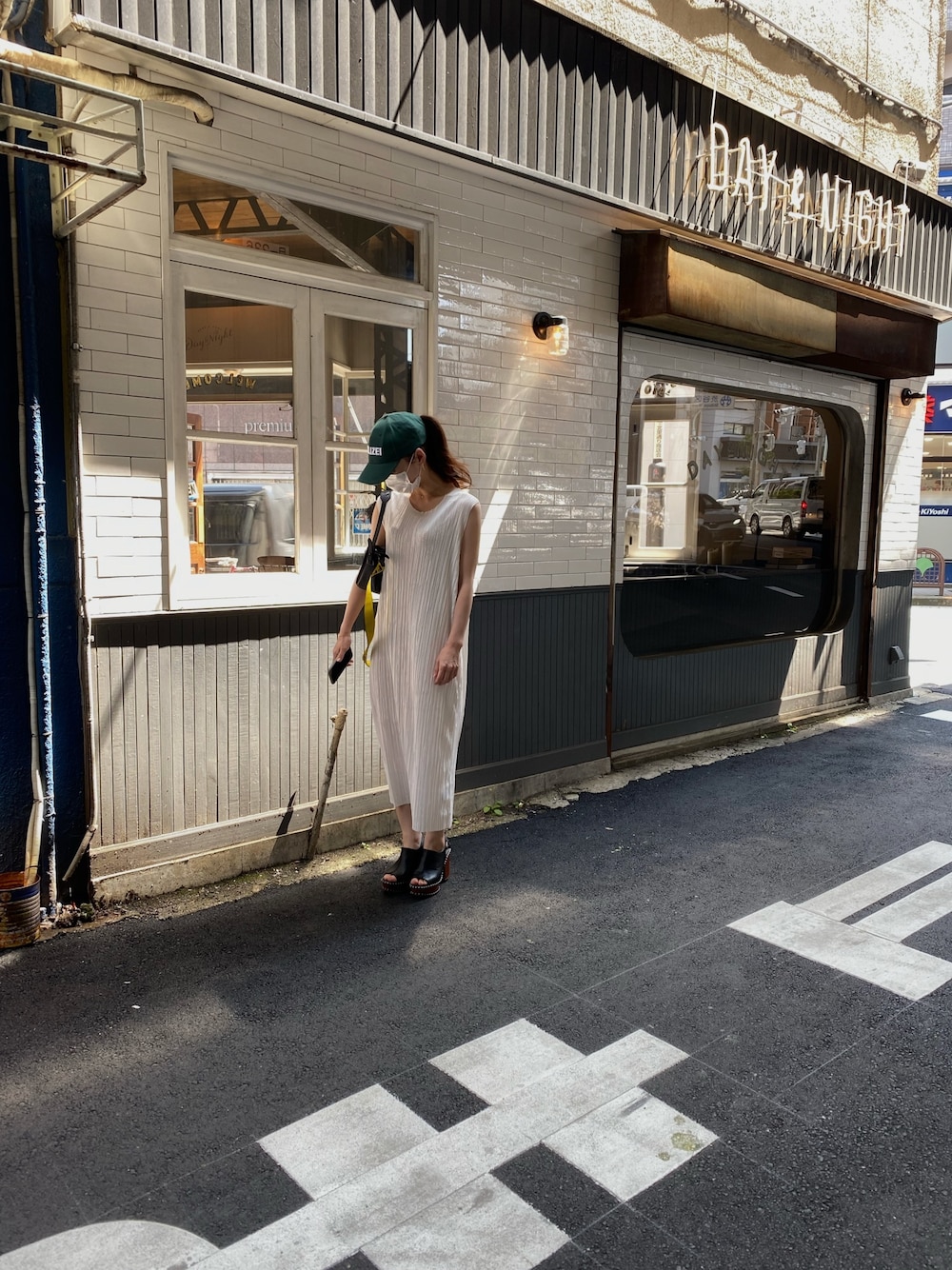 ホワイト系のワンピース/ドレス、ブラック系のショルダーバッグ、グリーン系のキャップを着用したレディースの春コーディネートの1枚目の写真