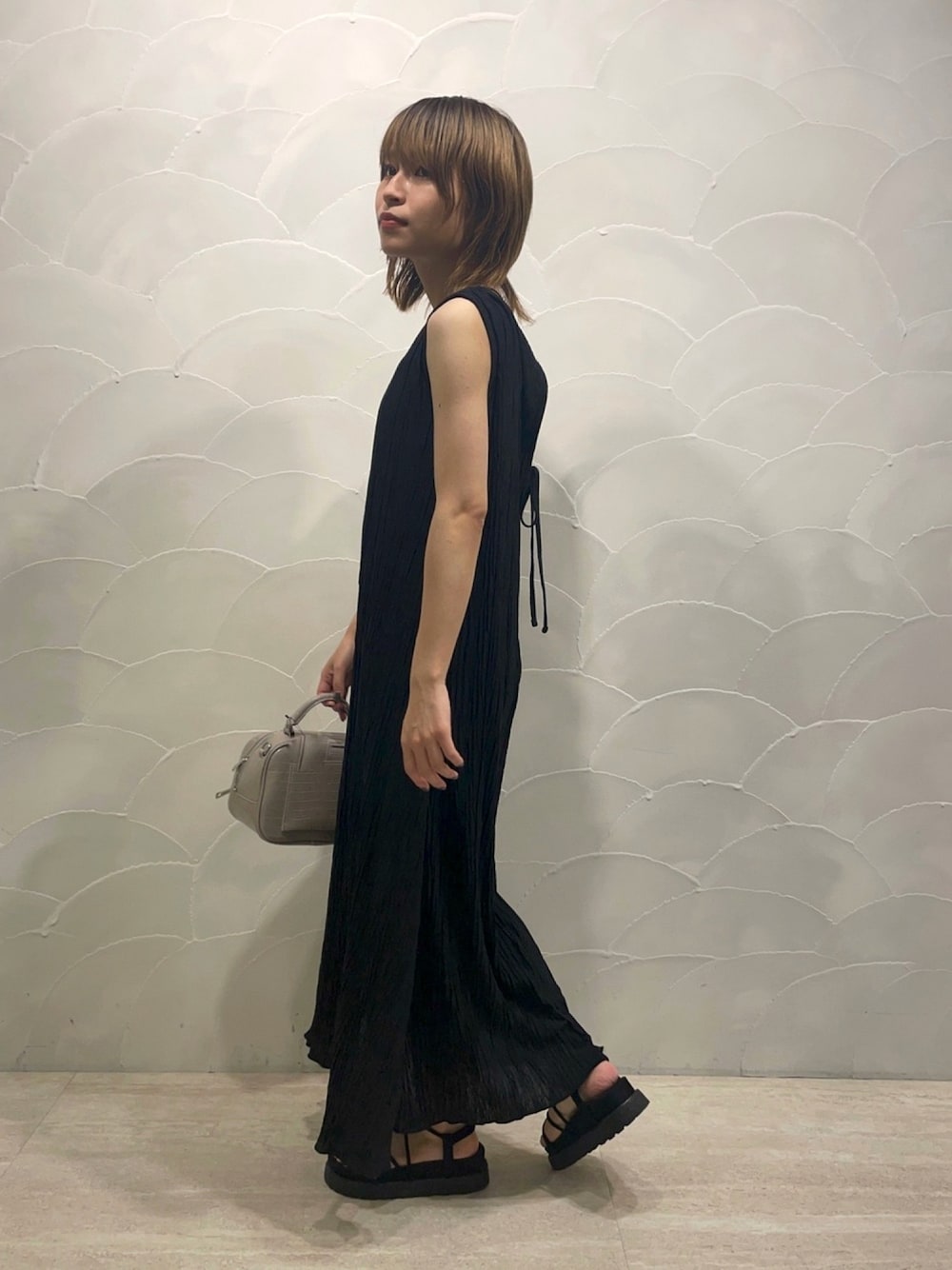 ブラック系のワンピース、ブラック系のキャミソール、ブラック系のサンダルを着用したレディースの夏コーディネートの1枚目の写真