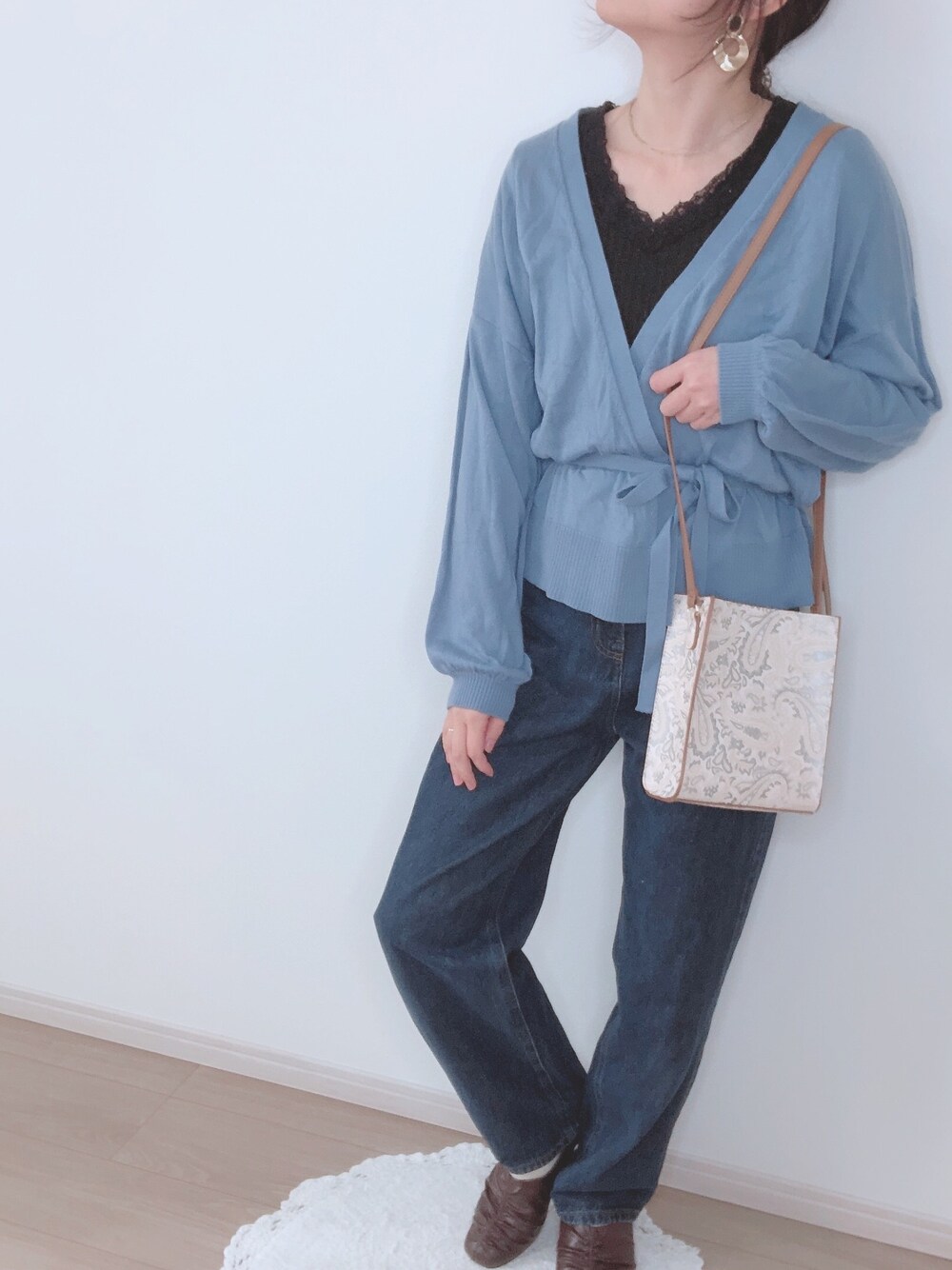 ブルー系のカーディガン/ボレロ、ホワイト系のショルダーバッグ、ブルー系のデニムパンツを着用したレディースの冬コーディネートの1枚目の写真