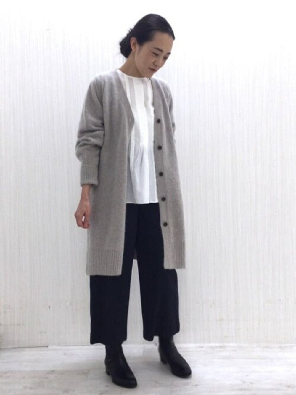 ベージュ系のカーディガン/ボレロ、ブルー系のその他パンツ、ブラック系のブーツを着用したレディースの秋コーディネートの1枚目の写真