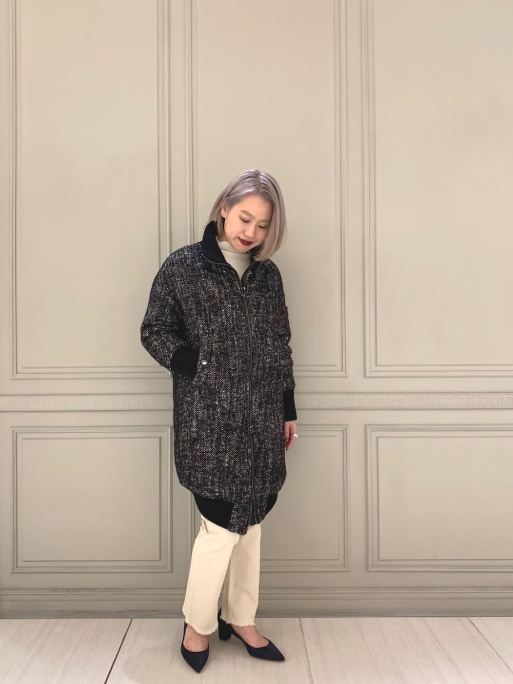 ホワイト系のニット/セーター、ブラック系のブルゾン、ホワイト系のデニムパンツを着用したレディースの秋コーディネートの1枚目の写真