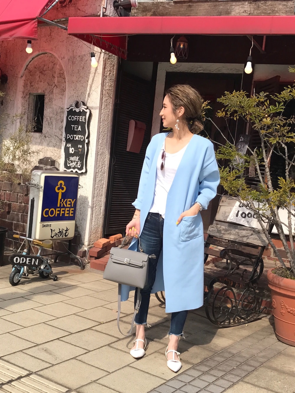 ブルー系のカーディガン/ボレロ、グレー系のショルダーバッグ、ホワイト系のパンプスを着用したレディースの春コーディネートの1枚目の写真