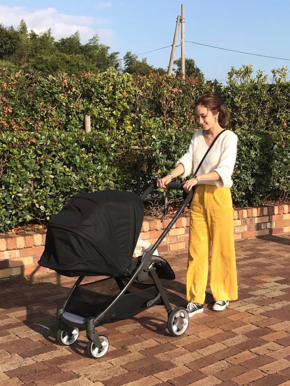 ホワイト系のニット/セーター、イエロー系のその他パンツ、ゴールド系のブレスレットを着用したレディースの秋コーディネートの1枚目の写真