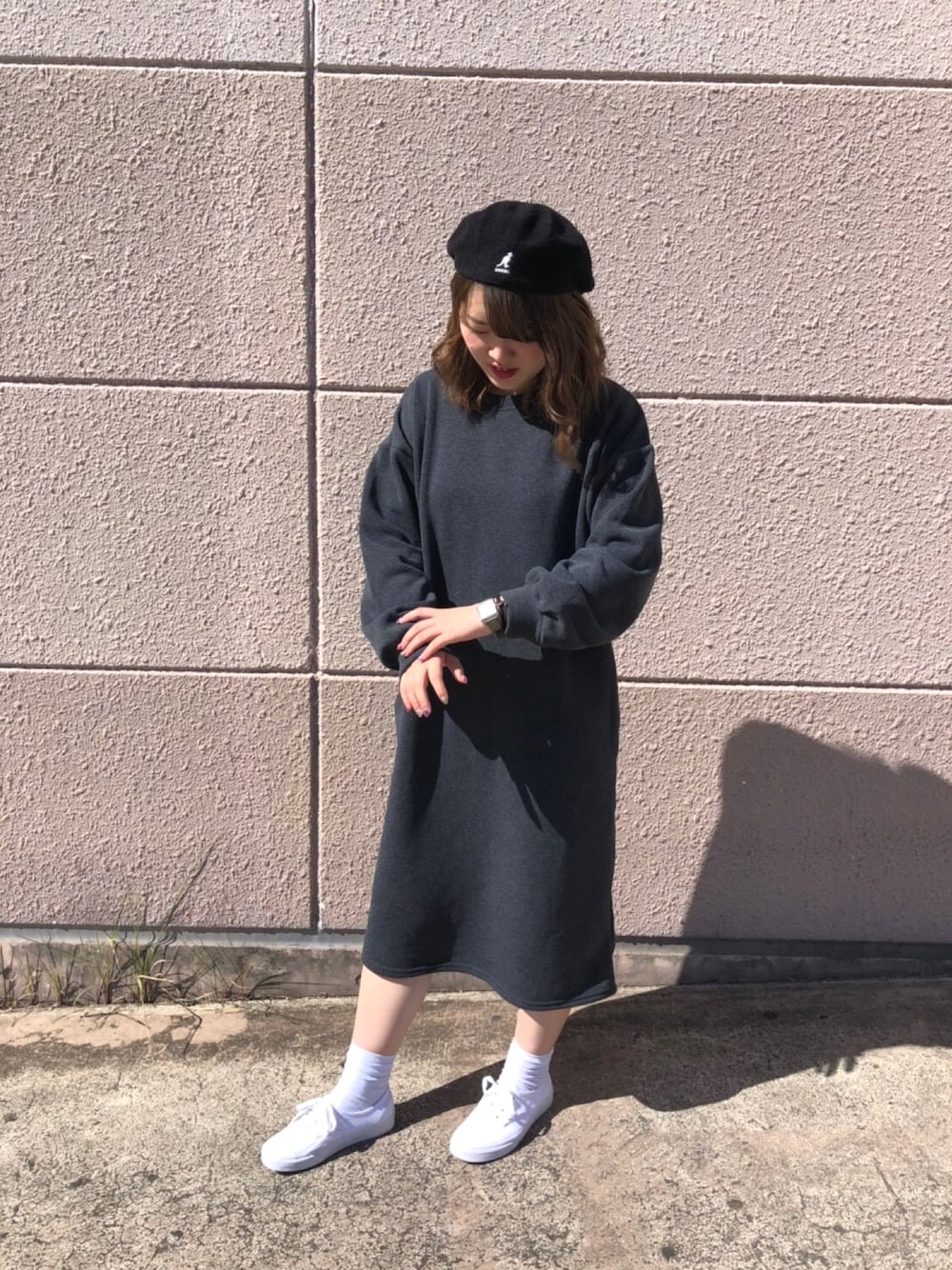 ホワイト系のスニーカー、グレー系のワンピース、ブラック系のハンチング/ベレー帽を着用したレディースの秋コーディネートの1枚目の写真