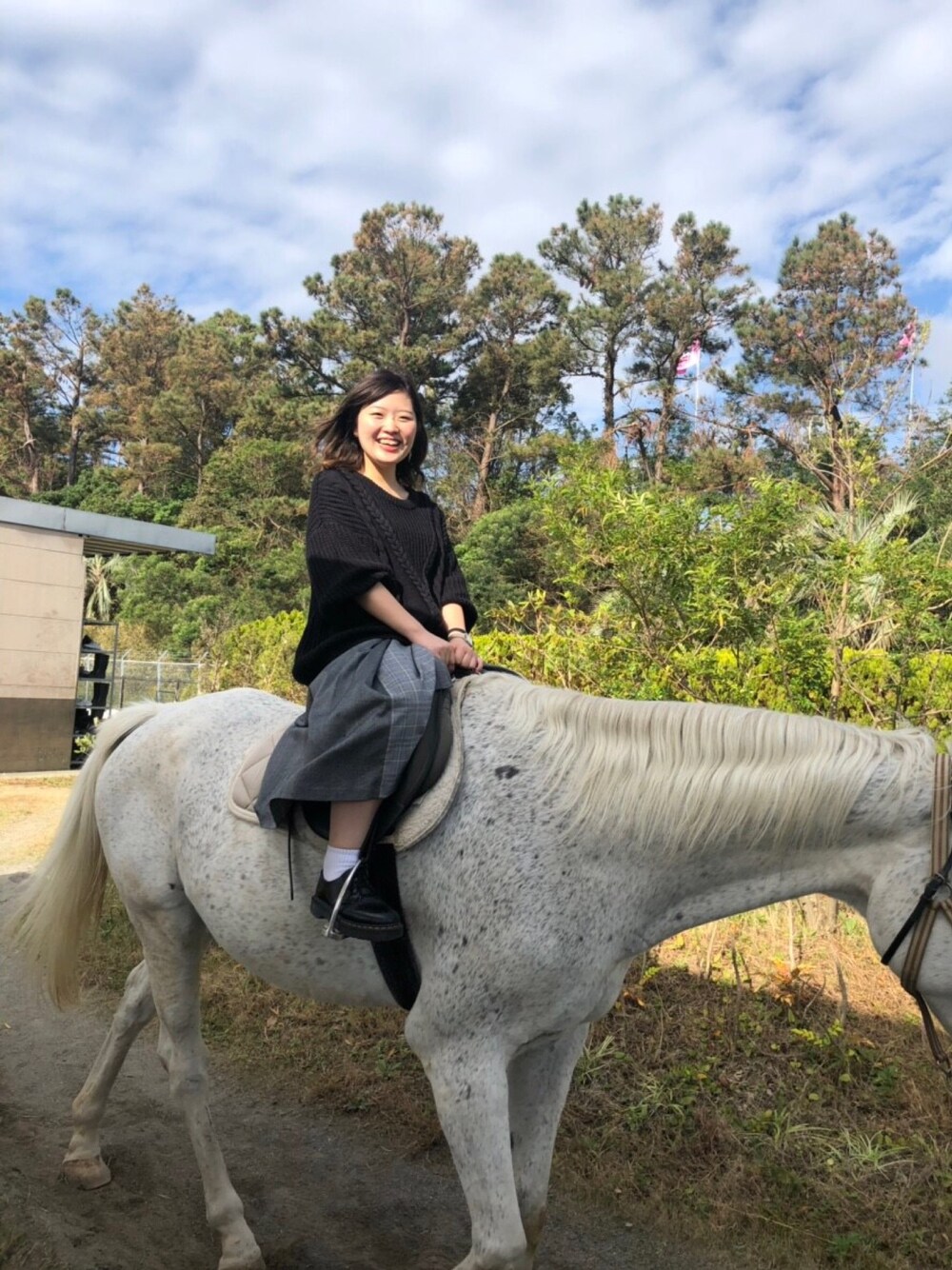 グレー系のスカート、ブラック系のニット/セーター、ブラック系のその他シューズを着用したレディースの秋コーディネートの1枚目の写真