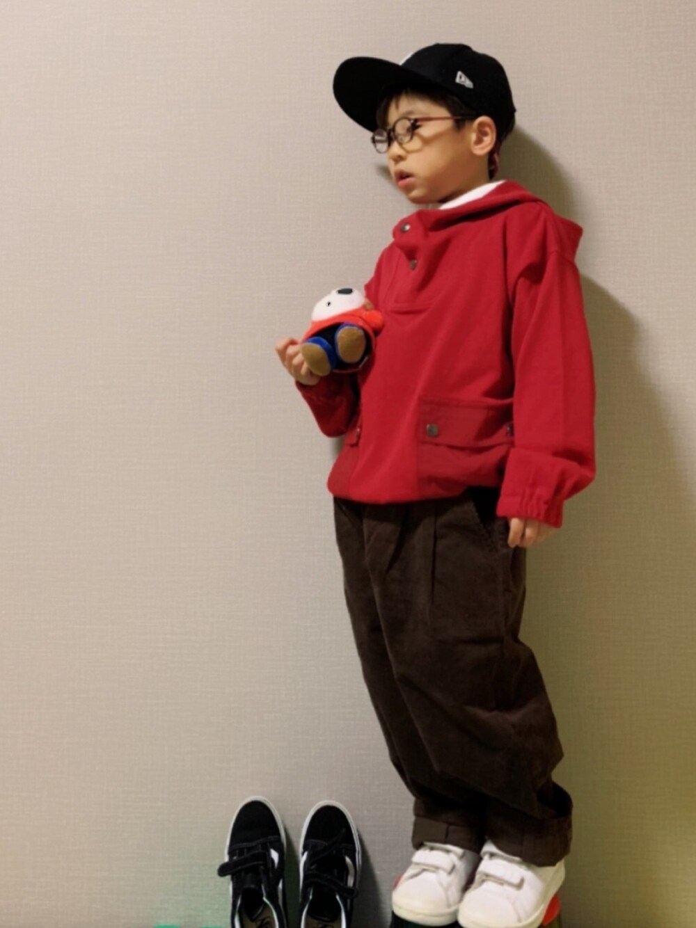 レッド系のパーカー、ホワイト系のシャツ/ブラウス、ブラウン系のその他パンツを着用したキッズの冬コーディネートの1枚目の写真