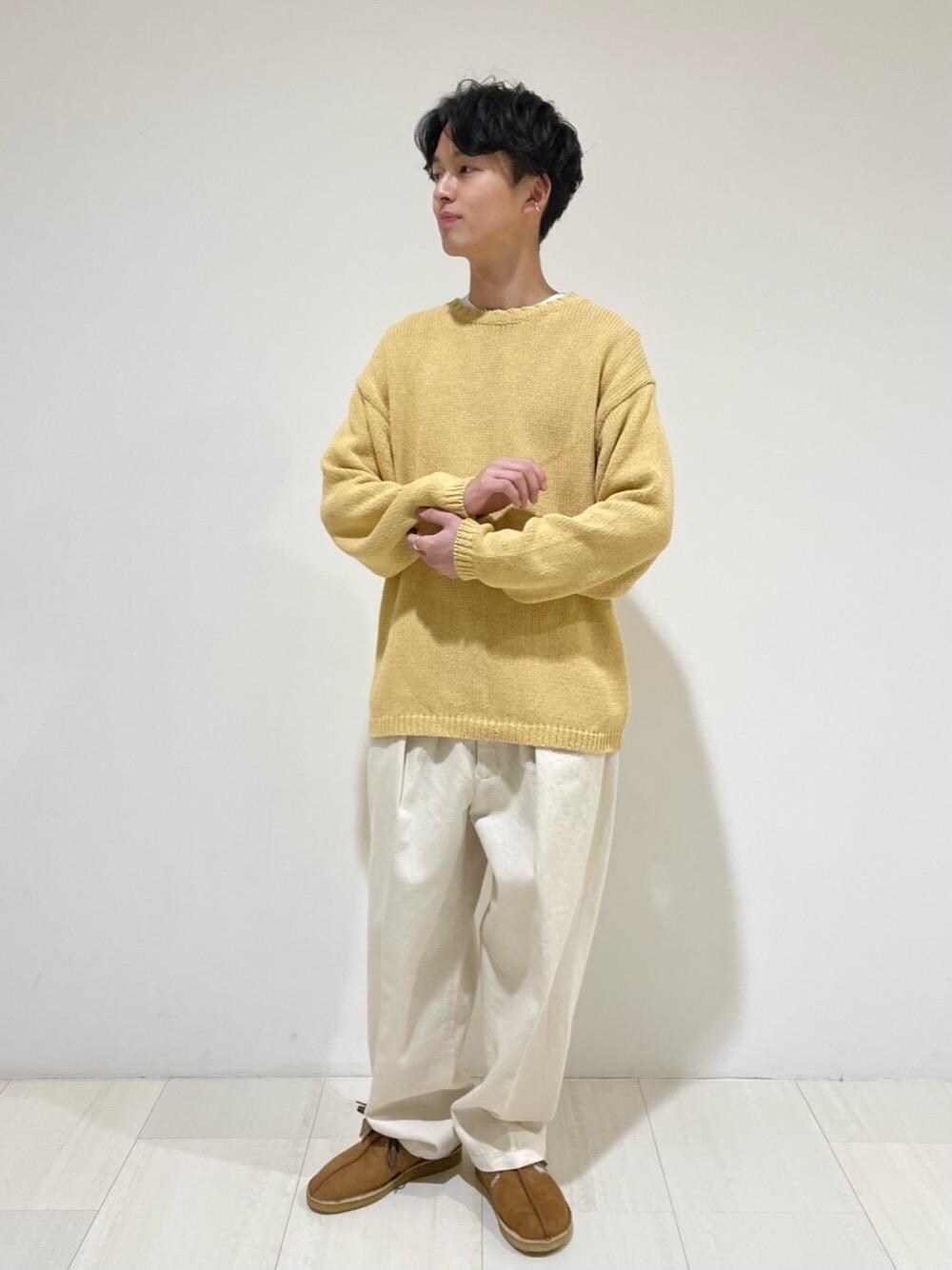 ブラウン系のブーツ、ホワイト系のデニムパンツ、イエロー系のニット/セーターを着用したメンズの冬コーディネートの1枚目の写真