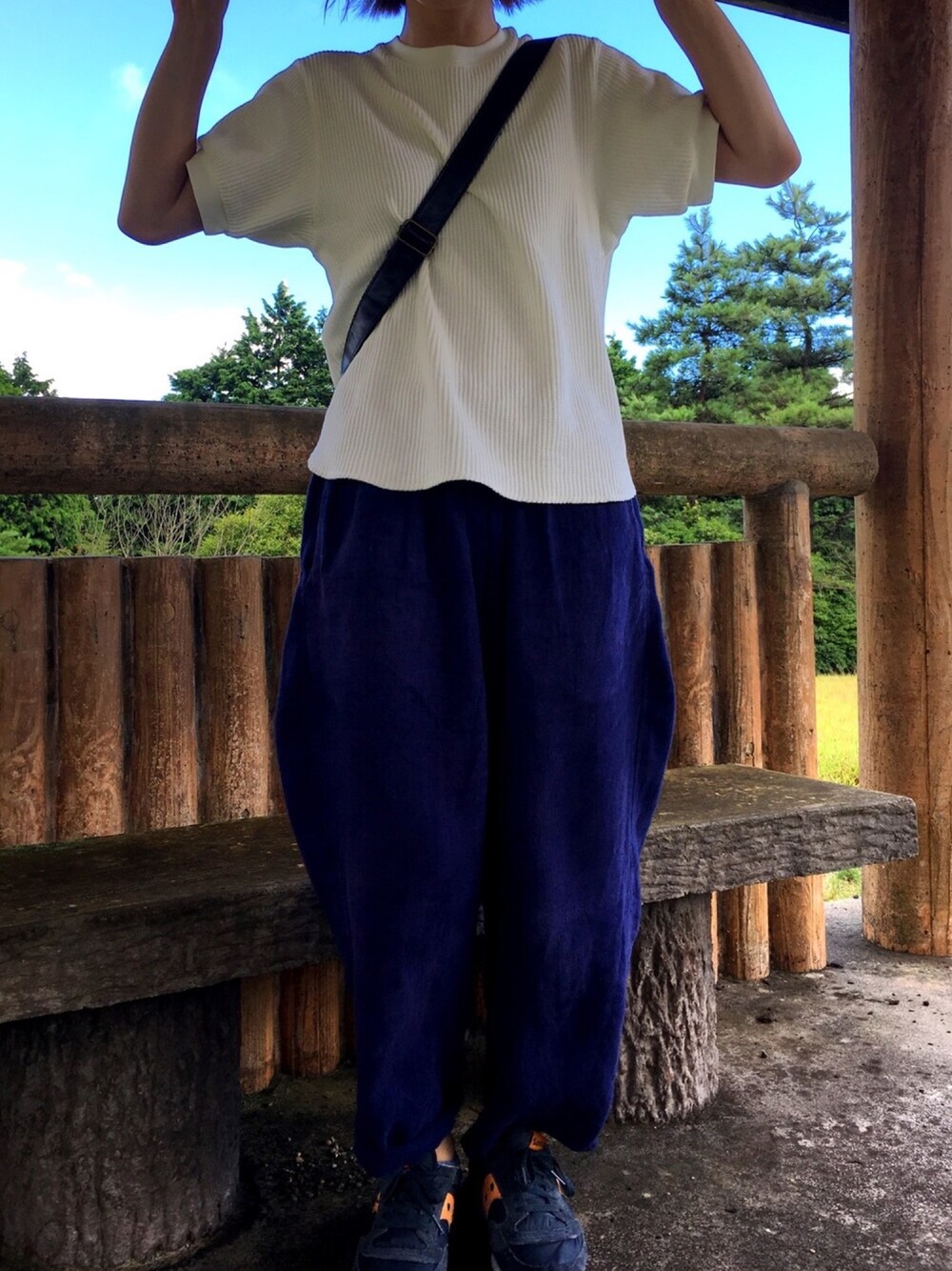 ホワイト系のTシャツ/カットソー、ブラック系のショルダーバッグ、ブルー系のスニーカーを着用したレディースの夏コーディネートの1枚目の写真