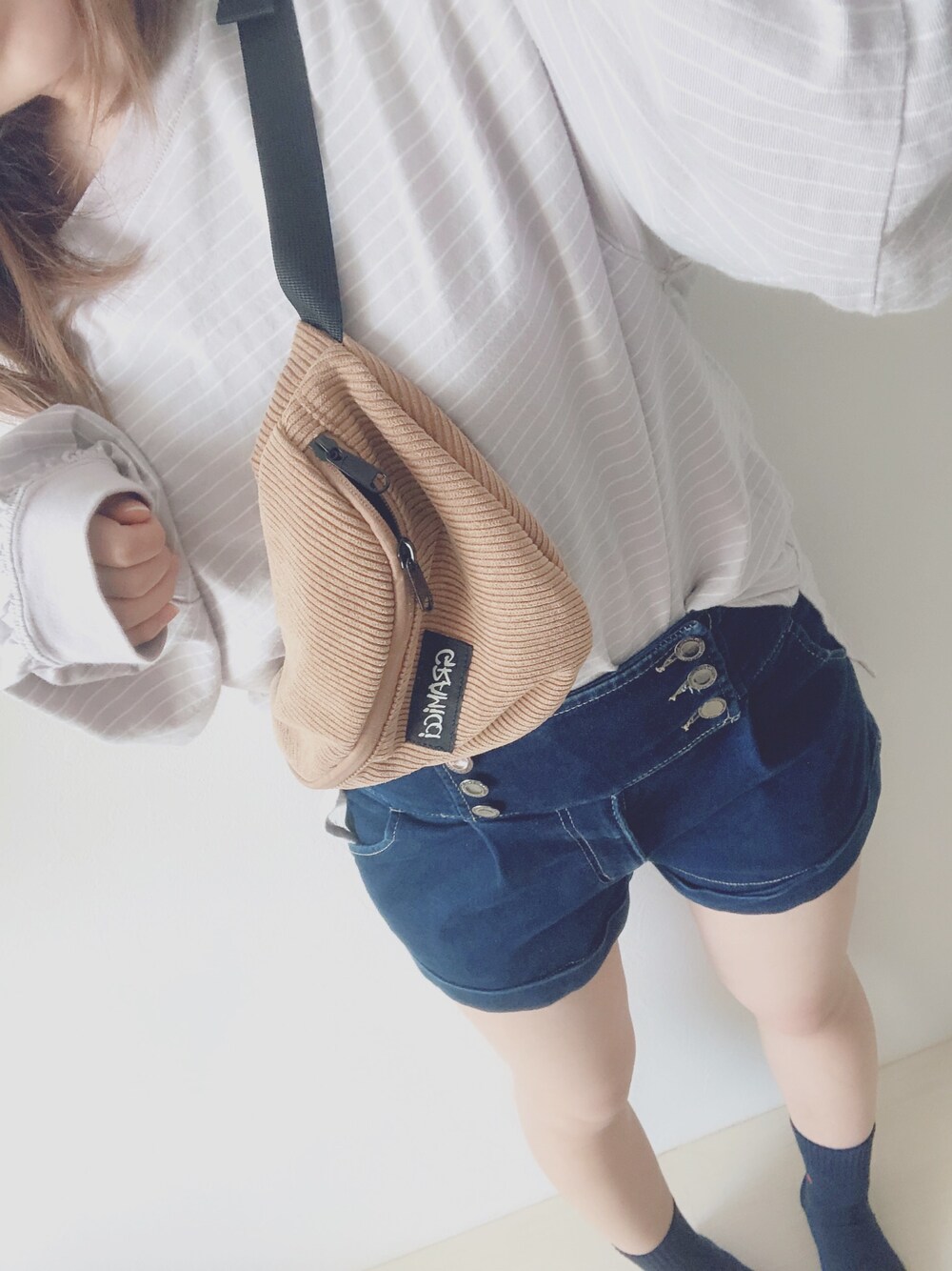 パープル系のTシャツ/カットソー、ブラウン系のボディバッグ/ウエストポーチを着用したレディースの春コーディネートの1枚目の写真