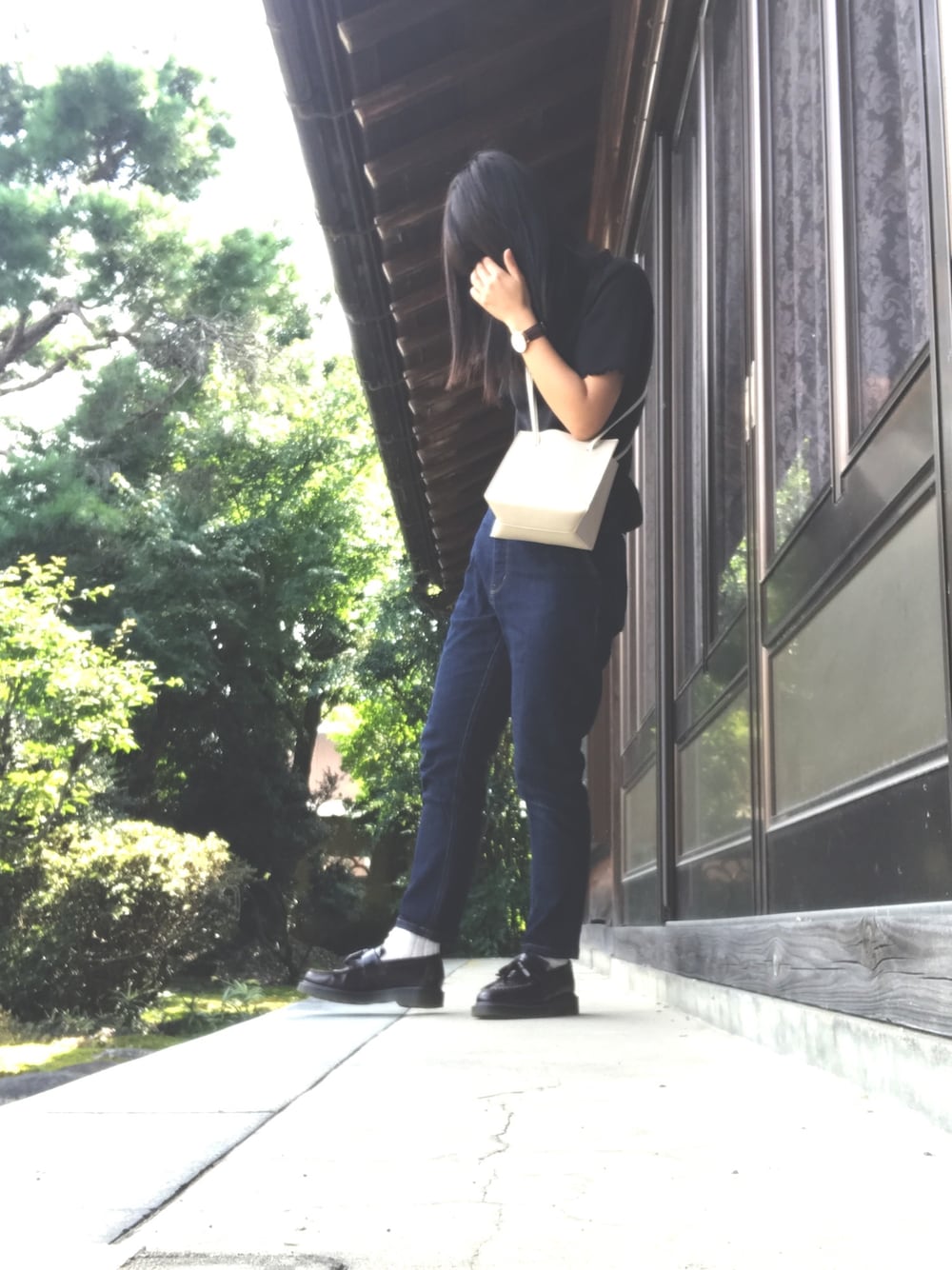 ホワイト系のショルダーバッグ、ブルー系のデニムパンツ、レッド系のローファーを着用したレディースの秋コーディネートの1枚目の写真