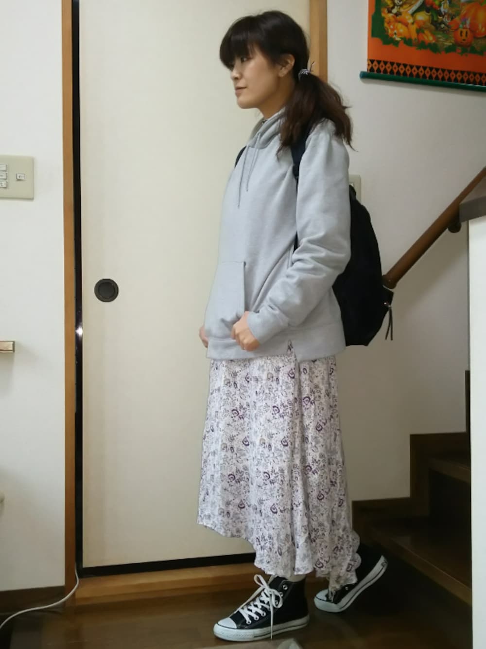 ベージュ系のスカート、ブラック系のスニーカー、グレー系のパーカーを着用したレディースの春コーディネートの1枚目の写真