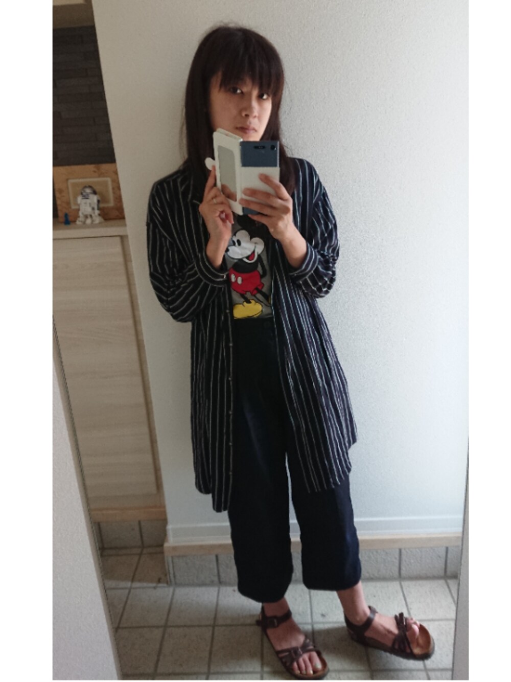 ブルー系のシャツワンピース、グレー系のTシャツ/カットソー、ブルー系のデニムパンツを着用したレディースの夏コーディネートの1枚目の写真