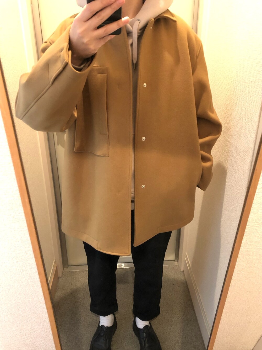 ベージュ系のジャケット/アウター、ブラック系のパンツ、ブラック系のモカシン/デッキシューズを着用したメンズの冬コーディネートの1枚目の写真