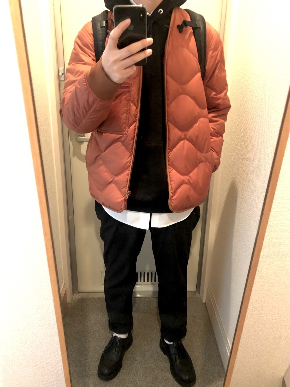 オレンジ系のジャケット/アウター、ブラック系のモカシン/デッキシューズ、ブラック系のパーカーを着用したメンズの冬コーディネートの1枚目の写真