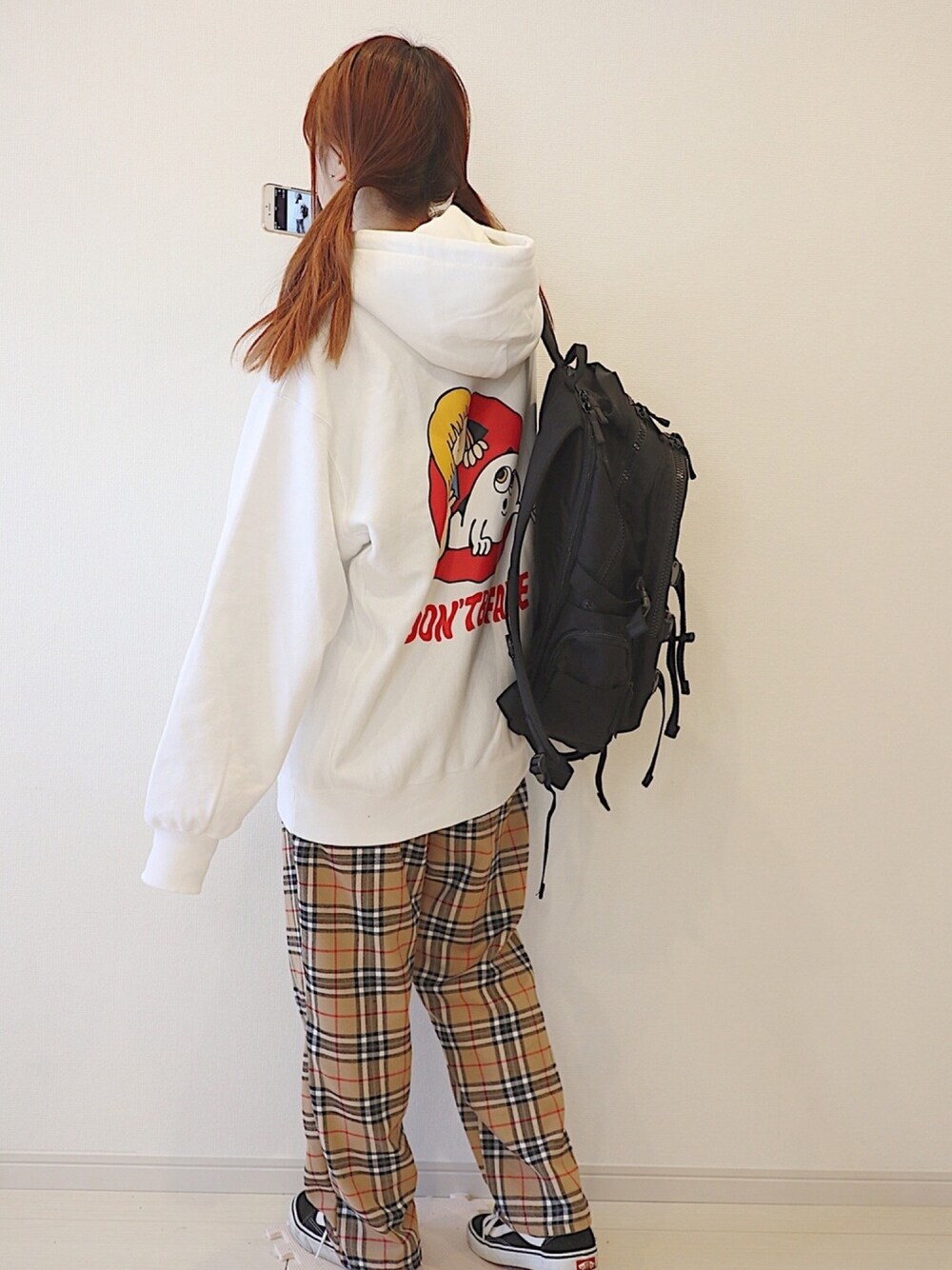 ブラック系のバックパック/リュック、ベージュ系のパンツ、ホワイト系のパーカーを着用したレディースの秋コーディネートの1枚目の写真