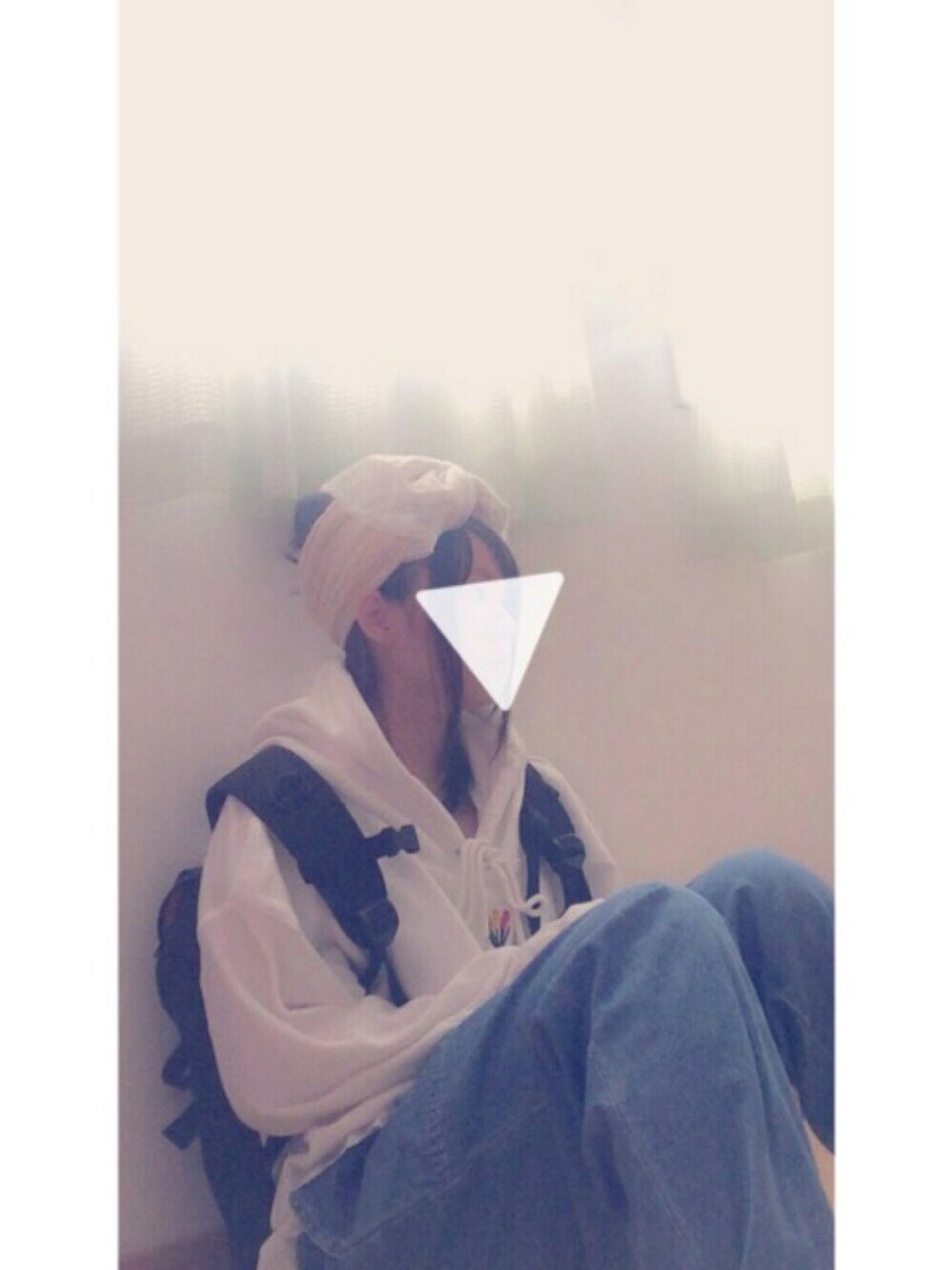 ホワイト系のパーカー、ブラック系のバックパック/リュック、ブルー系のデニムパンツを着用したレディースの秋コーディネートの1枚目の写真