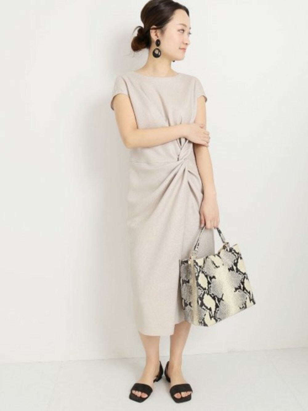 グレー系のサンダル、ベージュ系のワンピース、その他のショルダーバッグを着用したレディースの春コーディネートの1枚目の写真
