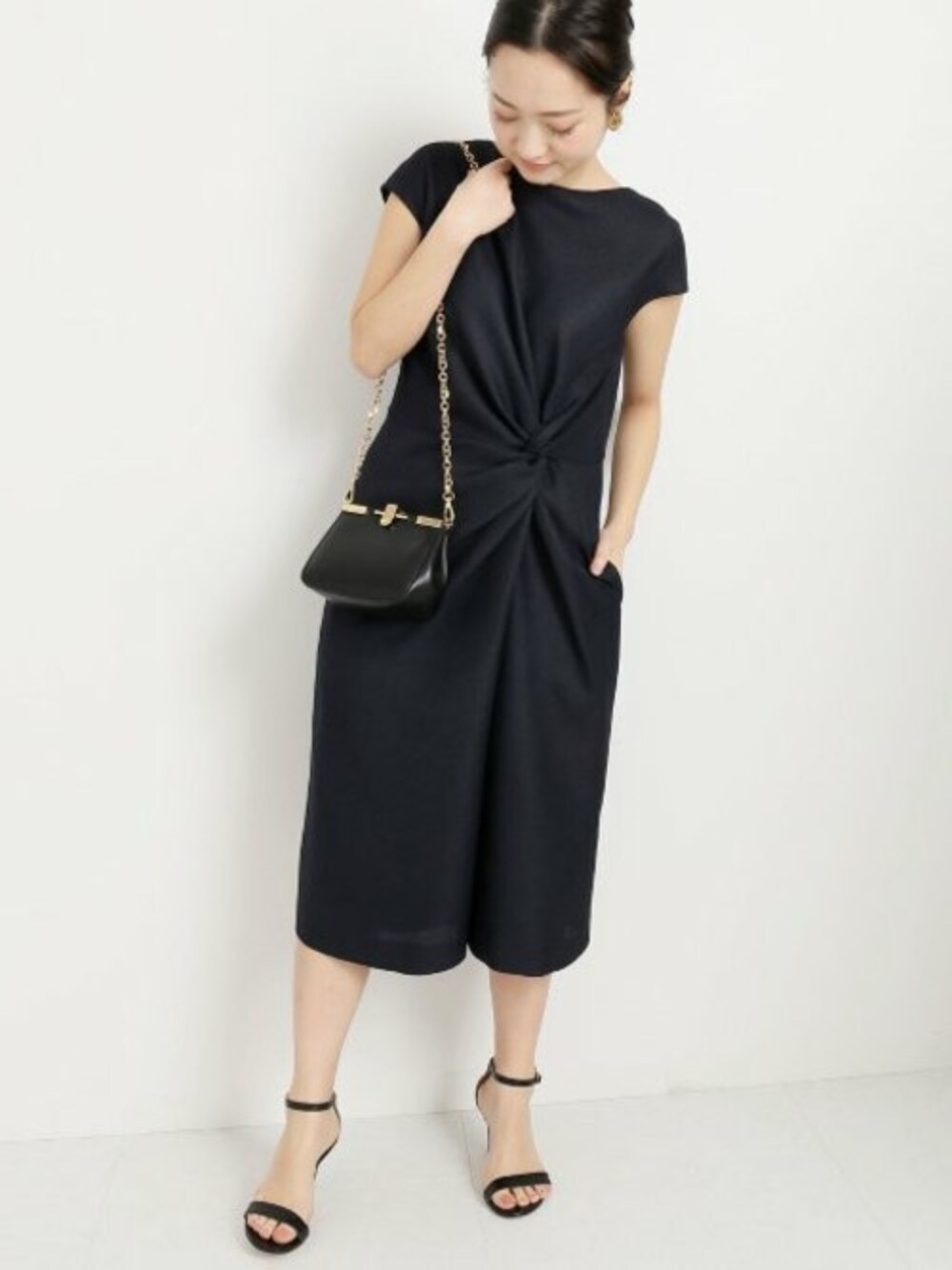 ブルー系のワンピース、ブラック系のショルダーバッグを着用したレディースの春コーディネートの1枚目の写真