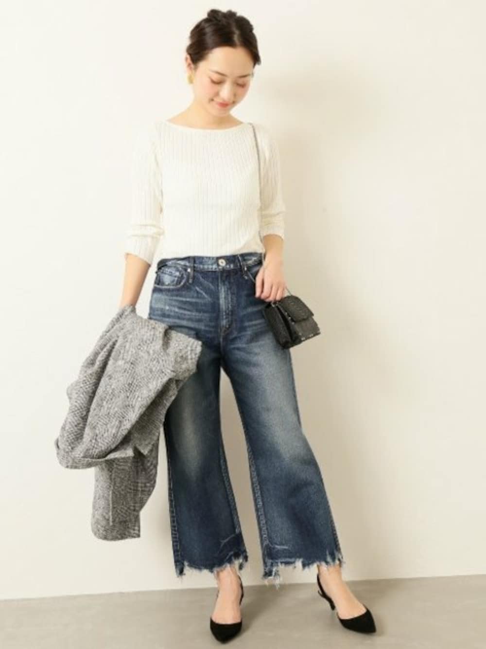 ブルー系のデニムパンツ、ブラック系のパンプス、ホワイト系のニット/セーターを着用したレディースの春コーディネートの1枚目の写真