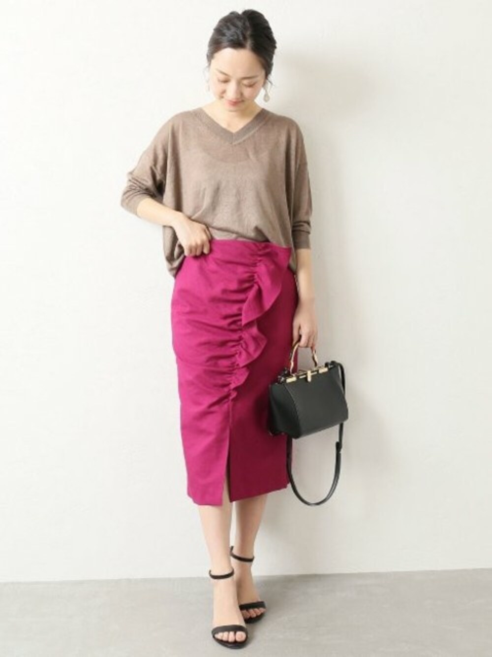 ベージュ系のニット/セーター、パープル系のスカート、ブラック系のショルダーバッグを着用したレディースの夏コーディネートの1枚目の写真