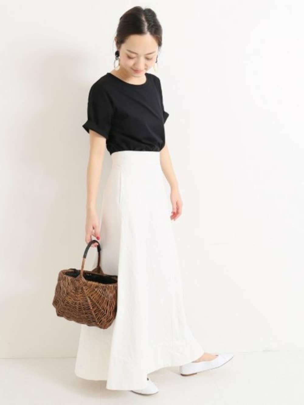 ホワイト系のデニムスカート、ブラック系のTシャツ/カットソー、ホワイト系のバレエシューズを着用したレディースの夏コーディネートの1枚目の写真