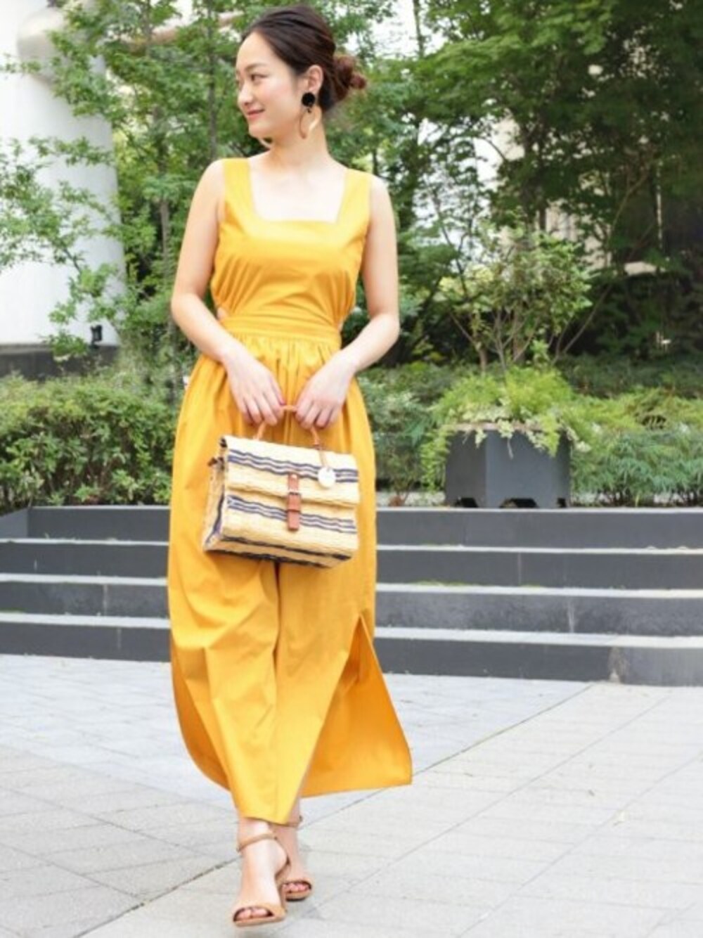 イエロー系のワンピース、ブルー系のかごバッグを着用したレディースの夏コーディネートの1枚目の写真