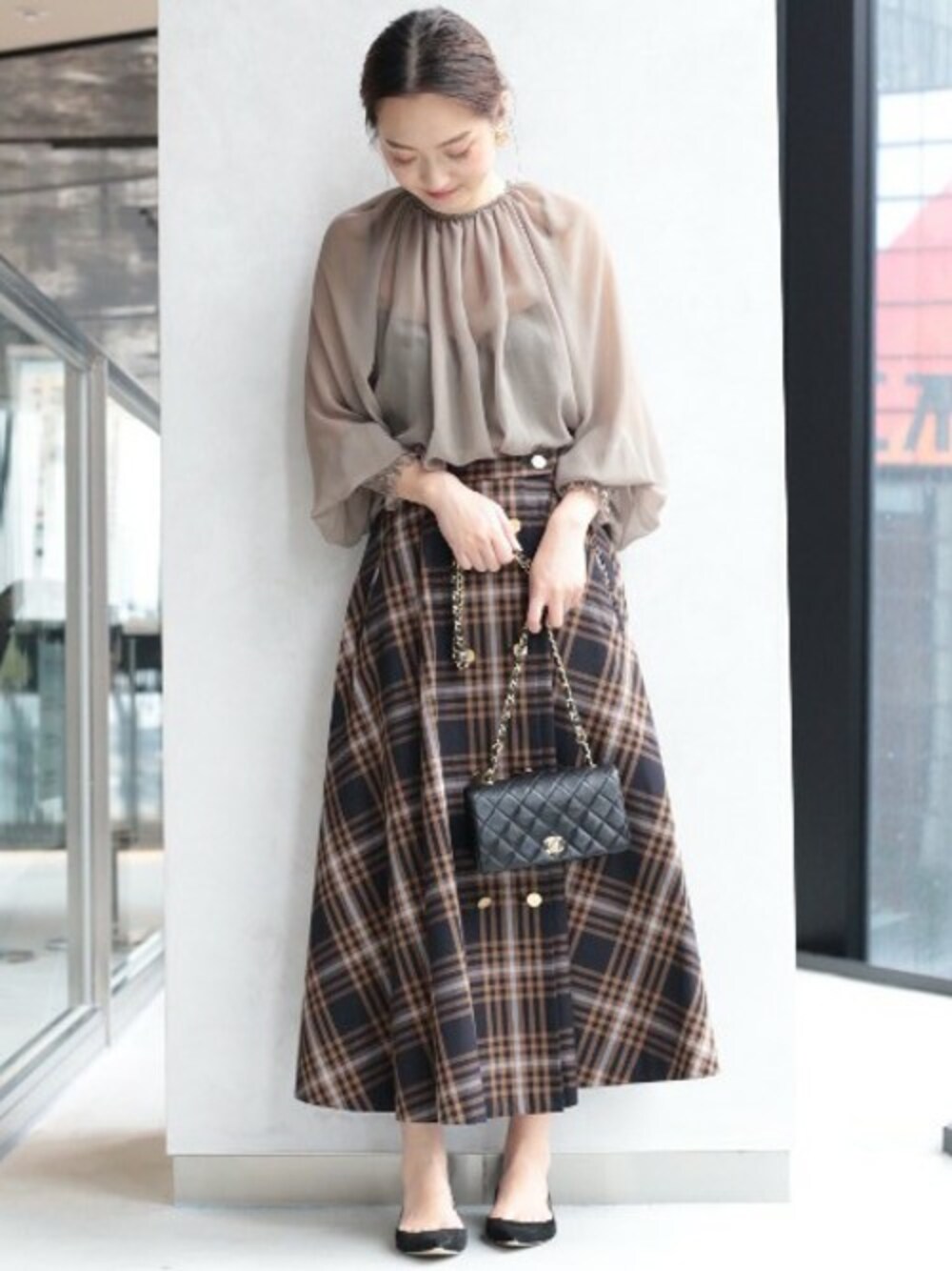 ブラック系のスカートを着用したレディースの夏コーディネートの1枚目の写真