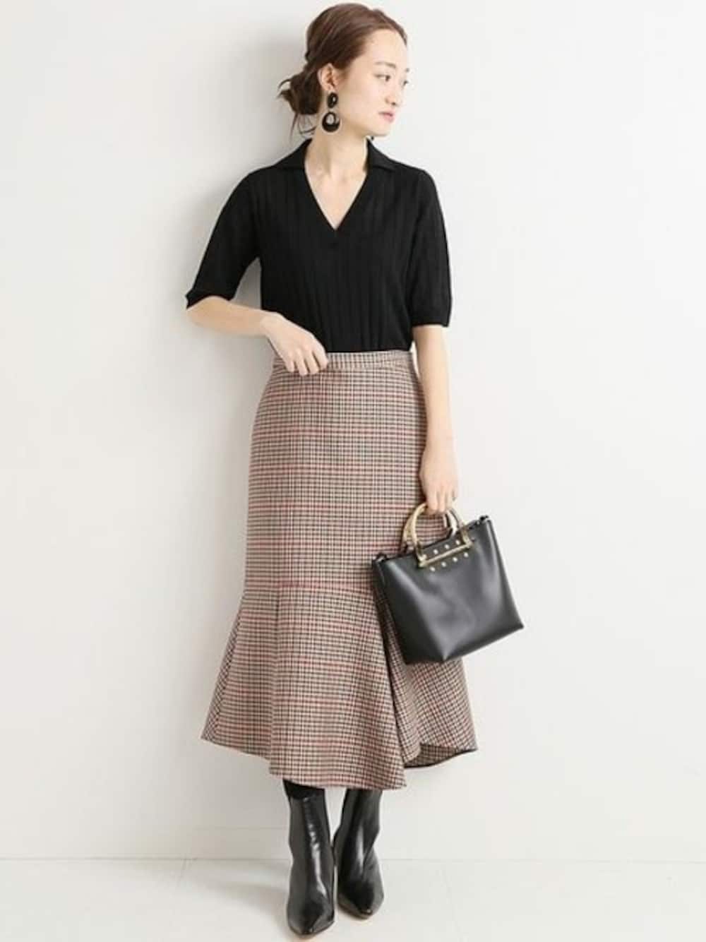 ブラウン系のスカート、ブラック系のニット/セーター、ブラック系のショルダーバッグを着用したレディースの秋コーディネートの1枚目の写真