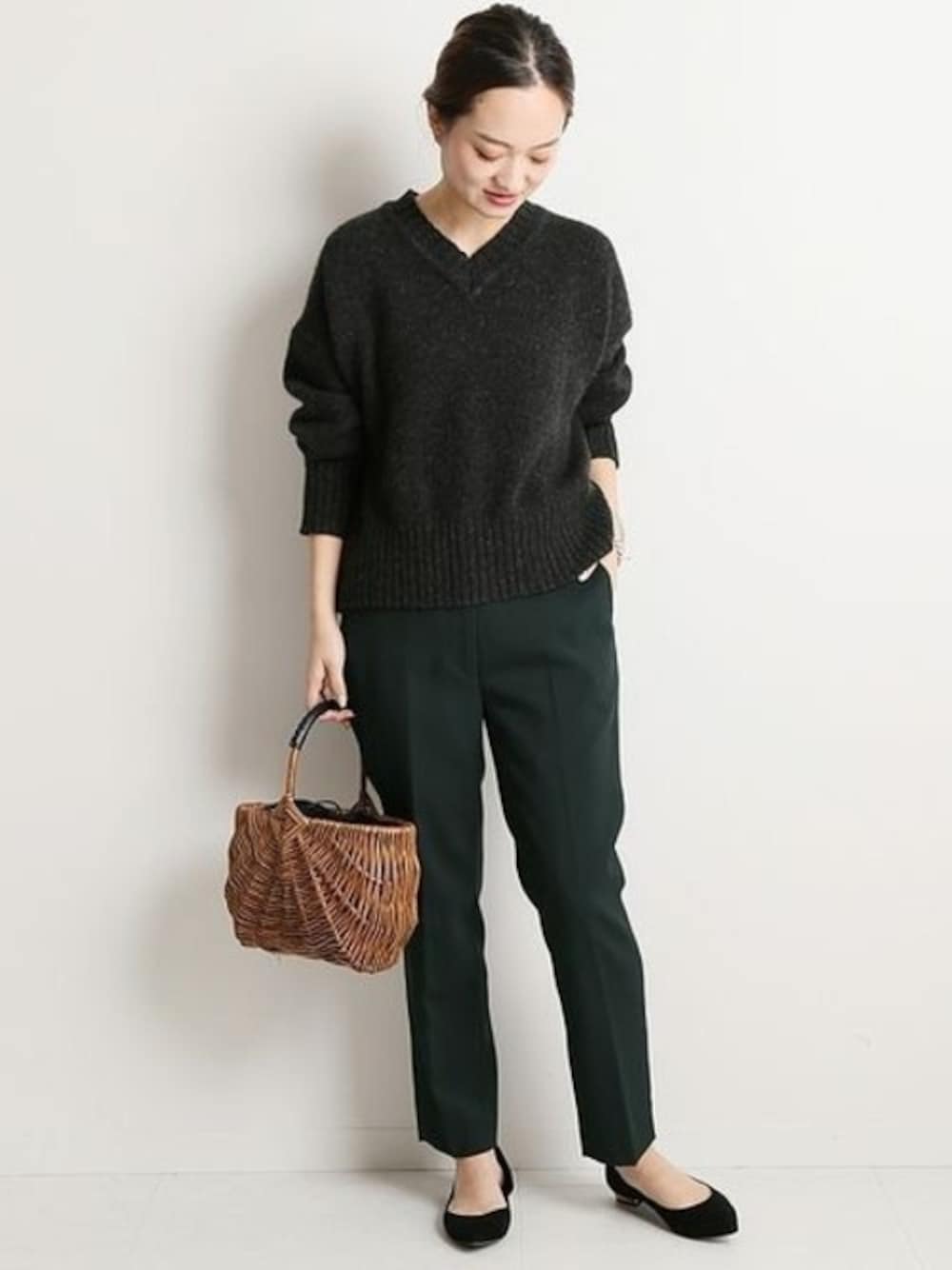 グリーン系のその他パンツ、グレー系のニット/セーター、ブラック系のかごバッグを着用したレディースの冬コーディネートの1枚目の写真