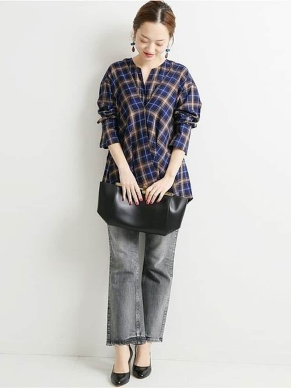 グレー系のデニムパンツ、ブルー系のシャツ/ブラウス、ブラック系のショルダーバッグを着用したレディースの冬コーディネートの1枚目の写真