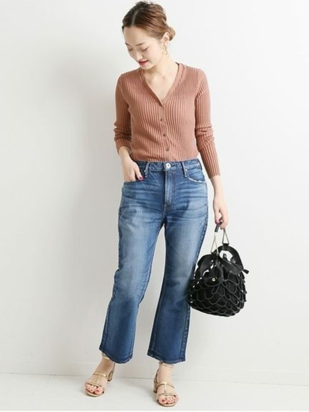 ブルー系のデニムパンツ、ブラック系のトートバッグを着用したレディースの冬コーディネートの1枚目の写真