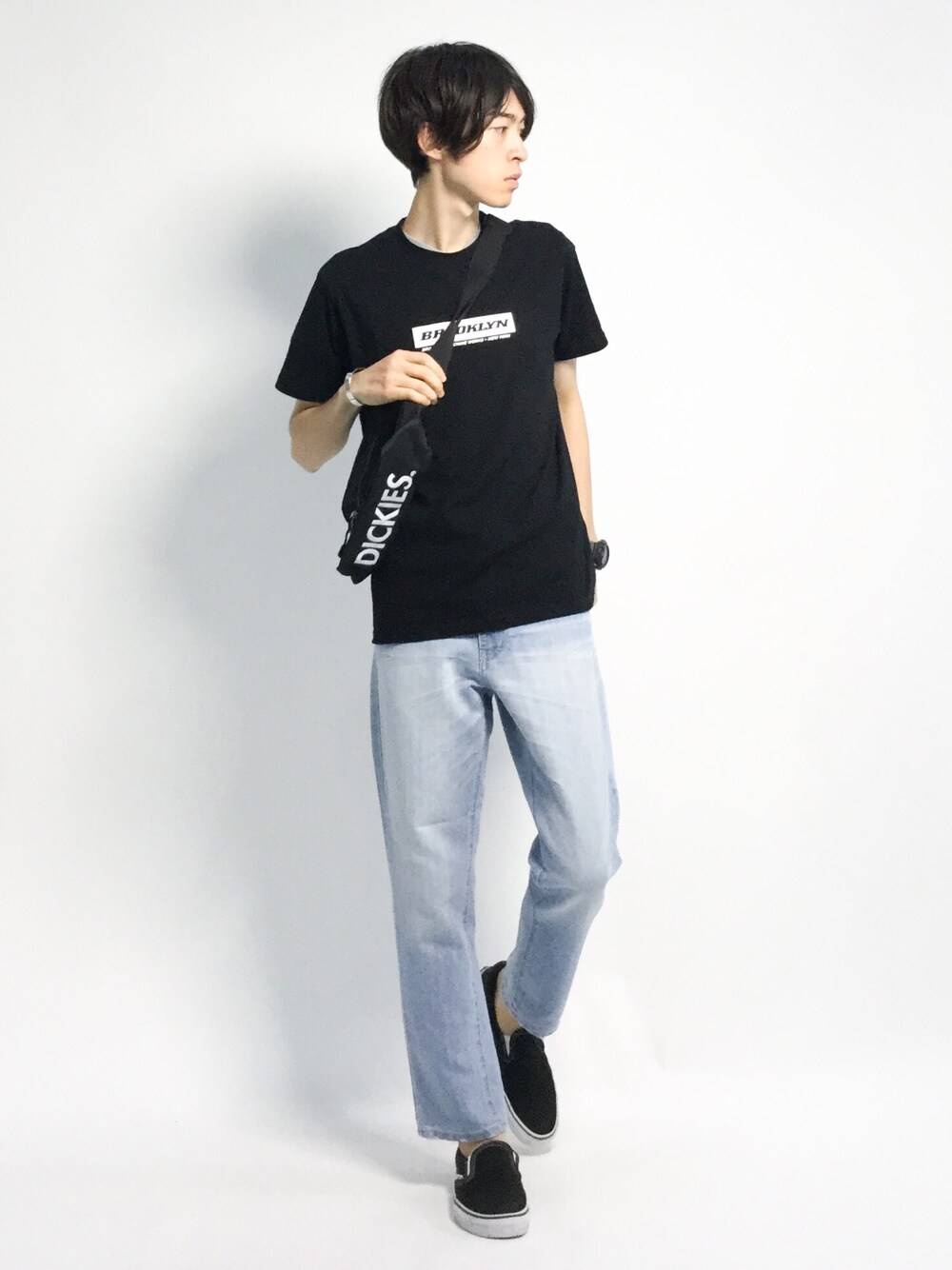 ブラック系のショルダーバッグ、ブラック系のTシャツ/カットソー、ブルー系のデニムパンツを着用したメンズの夏コーディネートの1枚目の写真