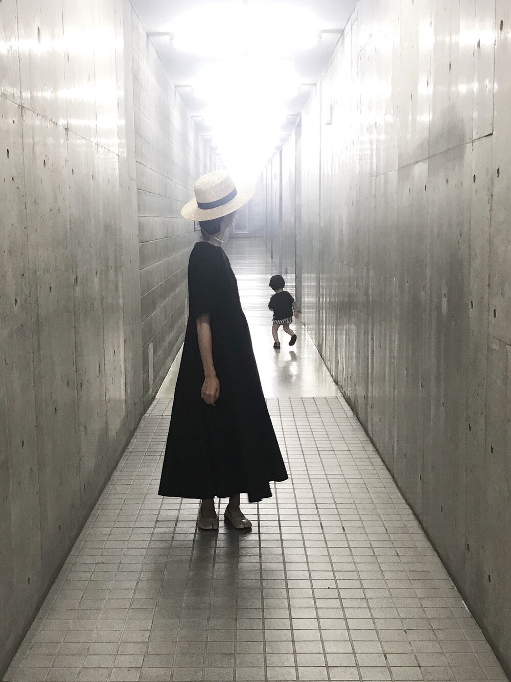 ブラック系のワンピース、ベージュ系のハットを着用したレディースの夏コーディネートの1枚目の写真