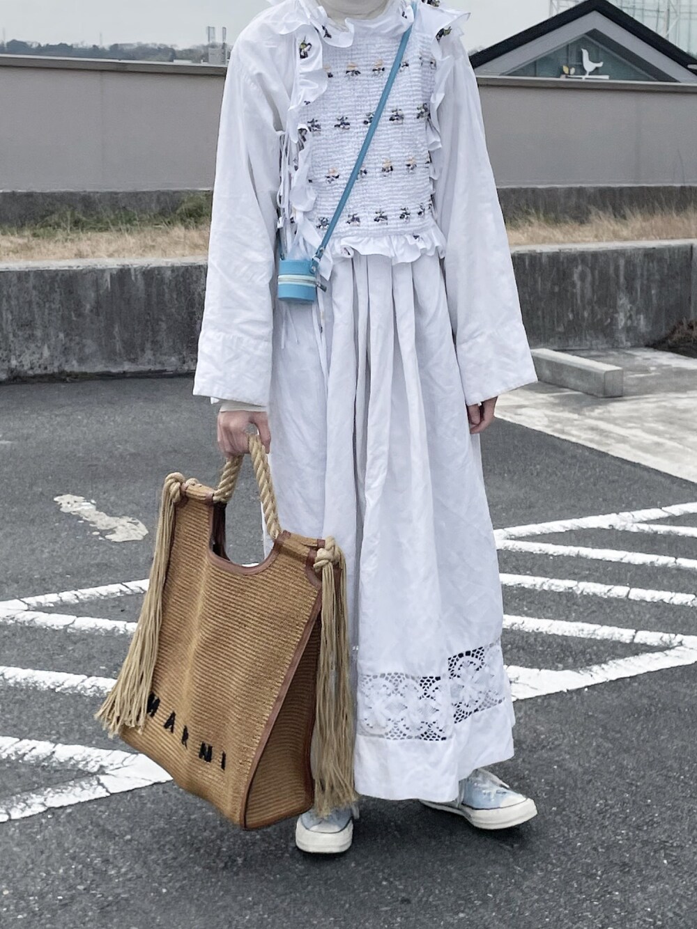 ベージュ系のトートバッグを着用したレディースの春コーディネートの1枚目の写真