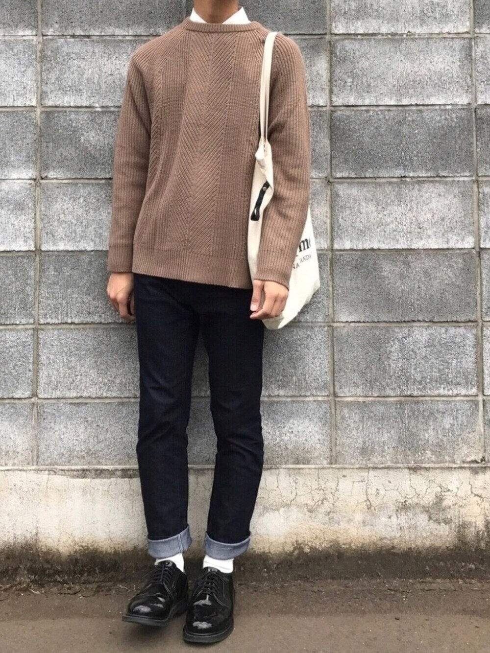 グリーン系のニット/セーター、ホワイト系のシャツ/ブラウス、ブルー系のデニムパンツを着用したメンズの秋コーディネートの1枚目の写真