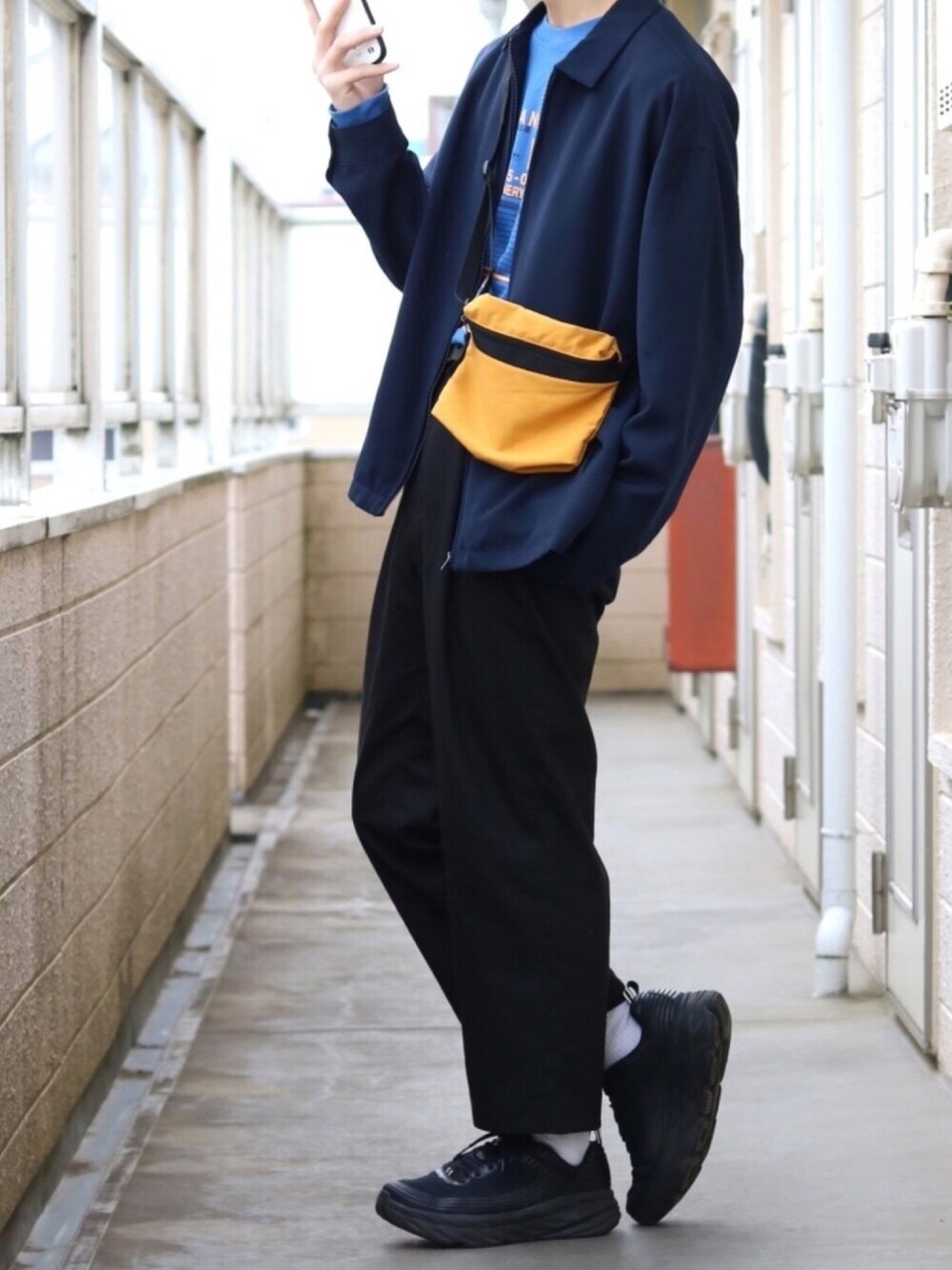 ブルー系のブルゾン、ブルー系のTシャツ/カットソー、イエロー系のバッグを着用したメンズの春コーディネートの1枚目の写真
