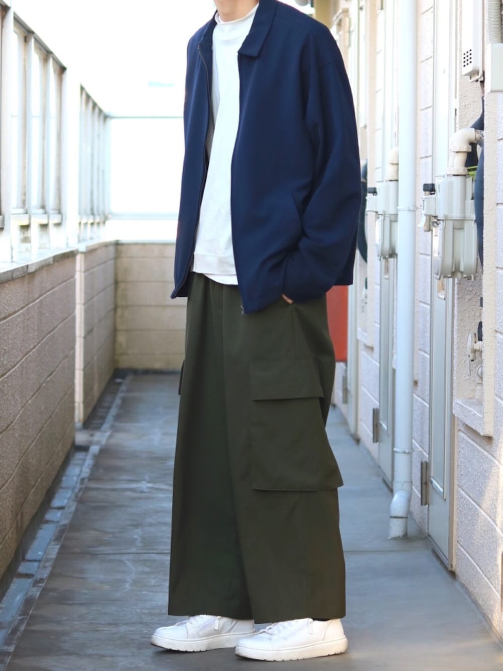 ブルー系のブルゾン、グレー系のTシャツ/カットソー、グレー系のカーゴパンツを着用したメンズの春コーディネートの1枚目の写真