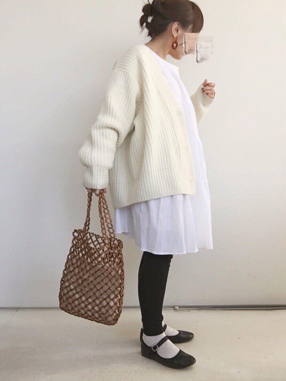 ホワイト系のワンピース、ホワイト系のカーディガン/ボレロ、ブラウン系のトートバッグを着用したレディースの春コーディネートの1枚目の写真