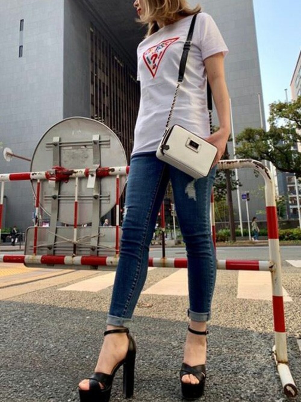 ホワイト系のTシャツ/カットソー、ブルー系のデニムパンツ、ホワイト系のショルダーバッグを着用したレディースの春コーディネートの1枚目の写真