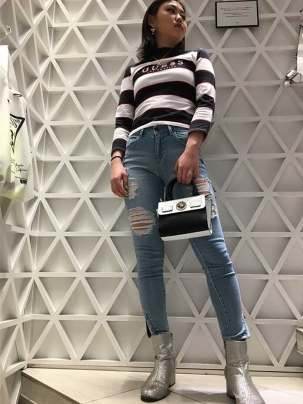 ブルー系のデニムパンツ、ホワイト系のショルダーバッグ、ホワイト系のTシャツ/カットソーを着用したレディースの春コーディネートの1枚目の写真