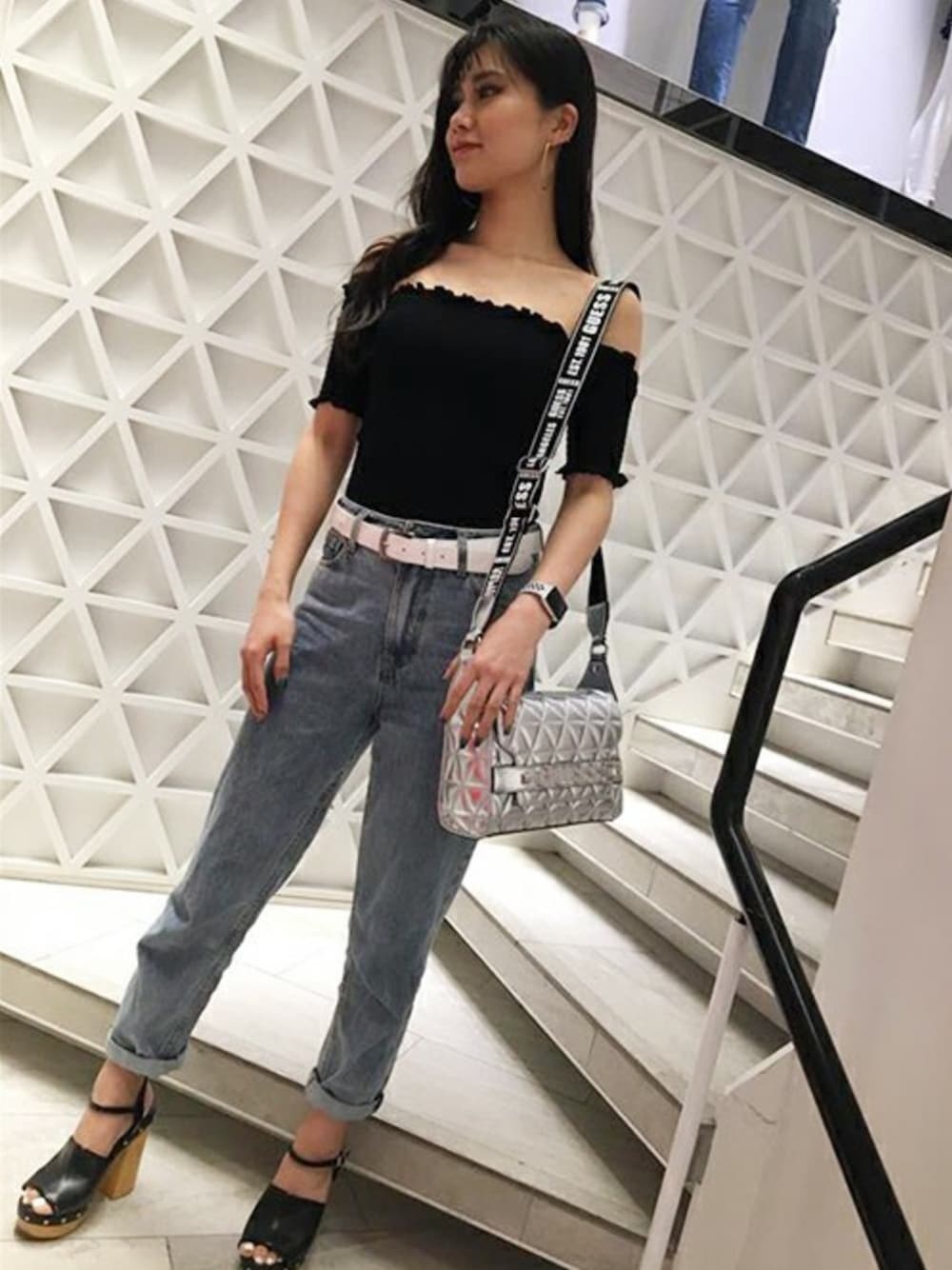 ブラック系のTシャツ/カットソー、ブルー系のデニムパンツ、シルバー系のショルダーバッグを着用したレディースの春コーディネートの1枚目の写真