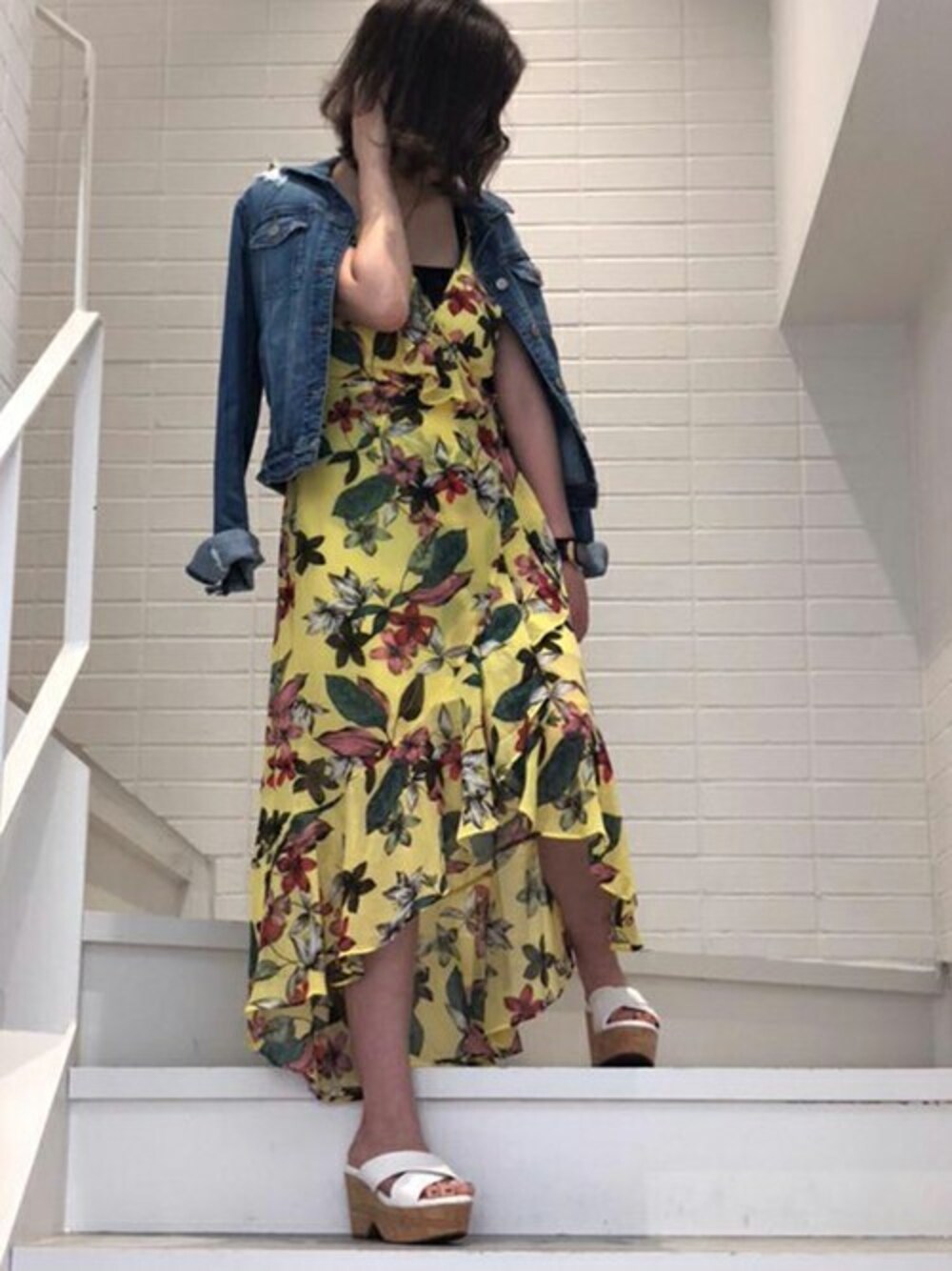 イエロー系のワンピース、ブルー系のデニムジャケットを着用したレディースの夏コーディネートの1枚目の写真