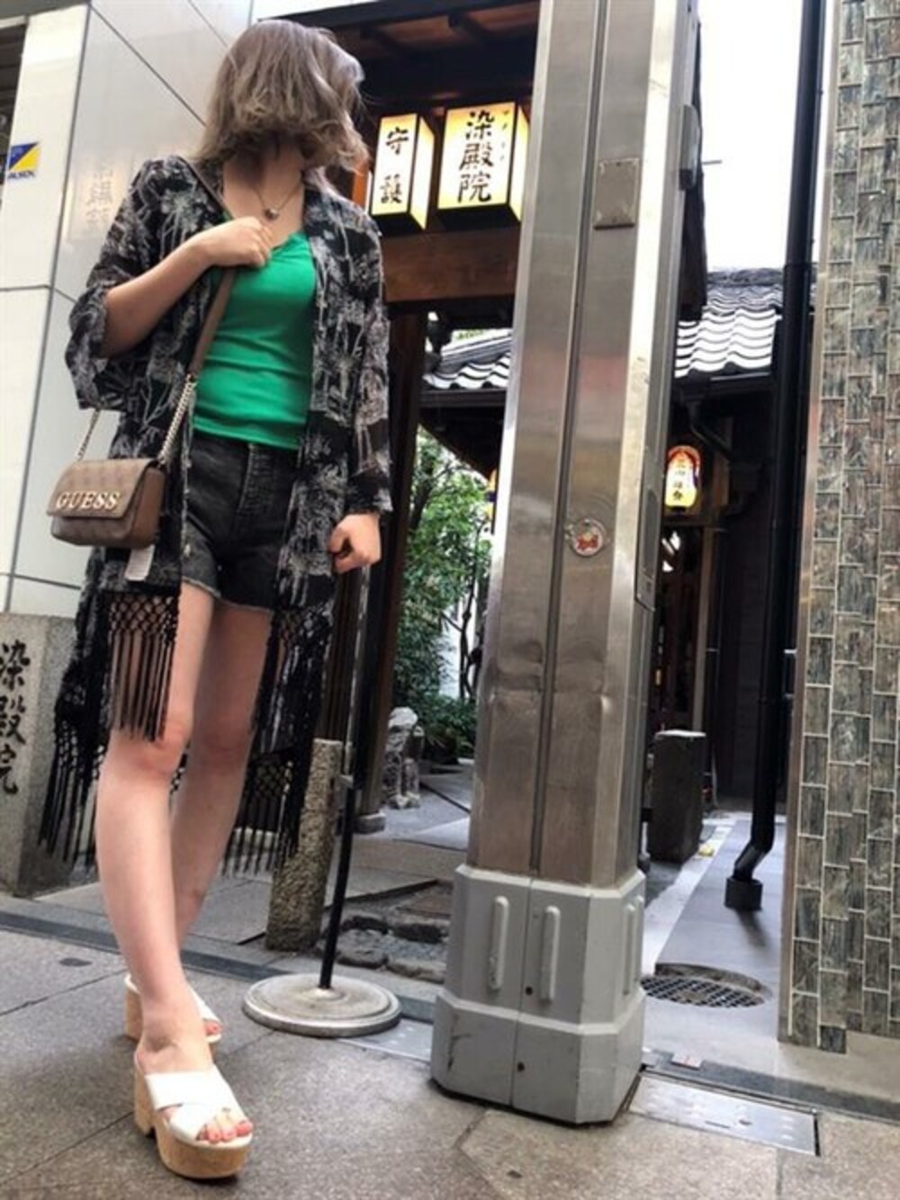 ブラック系のカーディガン/ボレロ、グリーン系のキャミソール、ブラック系のデニムパンツを着用したレディースの夏コーディネートの1枚目の写真